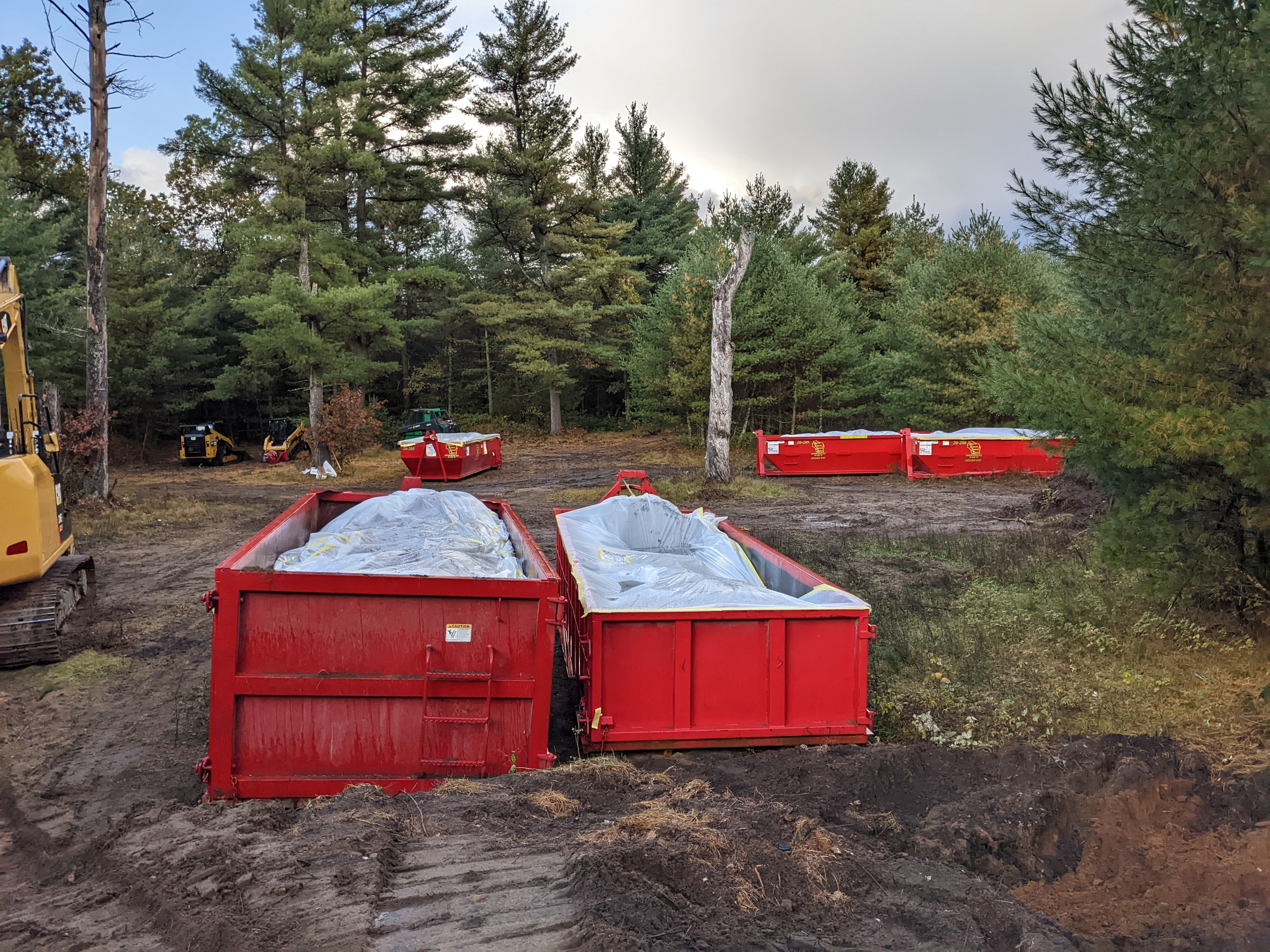 Two red industrial-sized dumpsters are full of debris on Zach Skrede's property