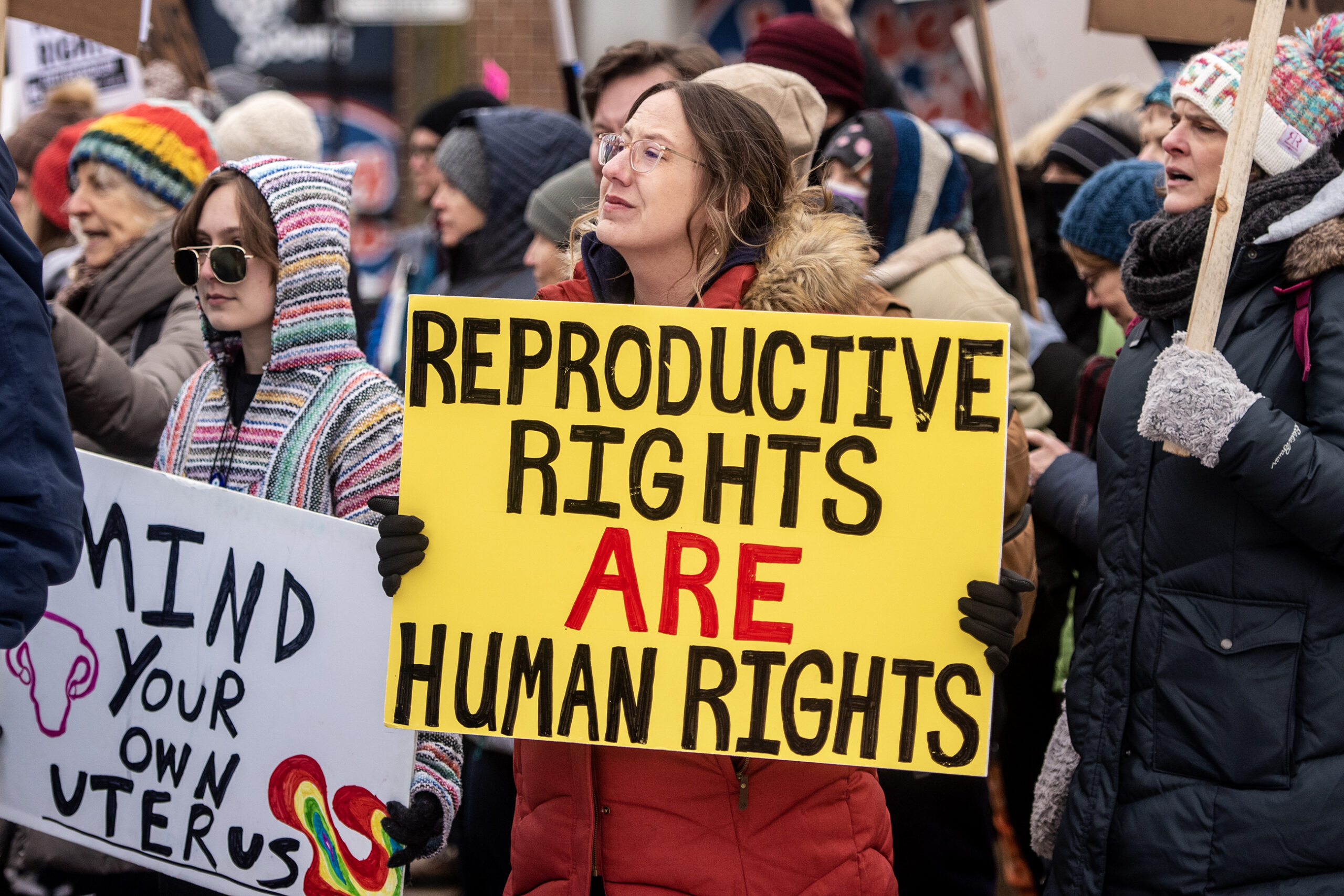A protester's yellow sign reads "Reproductive rights are human rights."