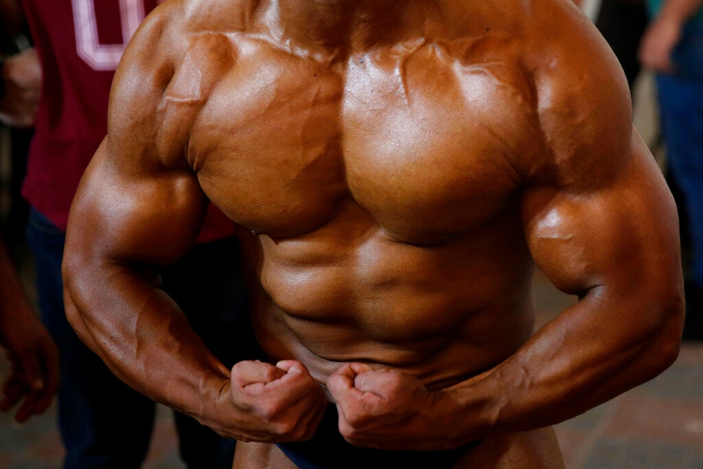 A contestant prepares himself before a local bodybuilding competition in 2019
