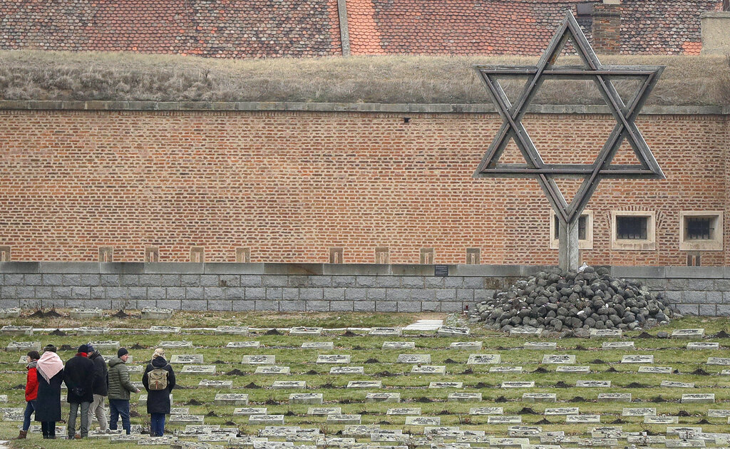 visitors at a former Nazi concentration camp, huge star of david in background