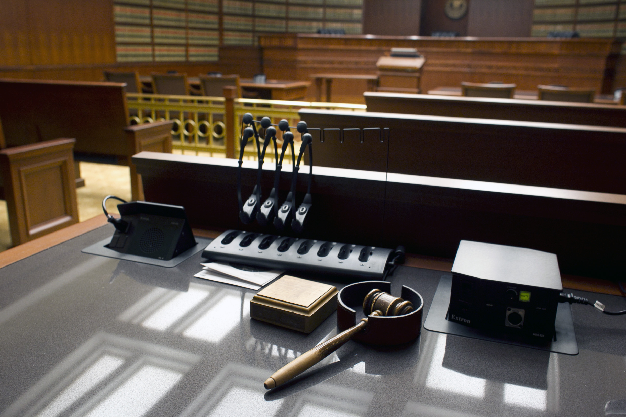 A gavel sits on a desk inside a courtroom