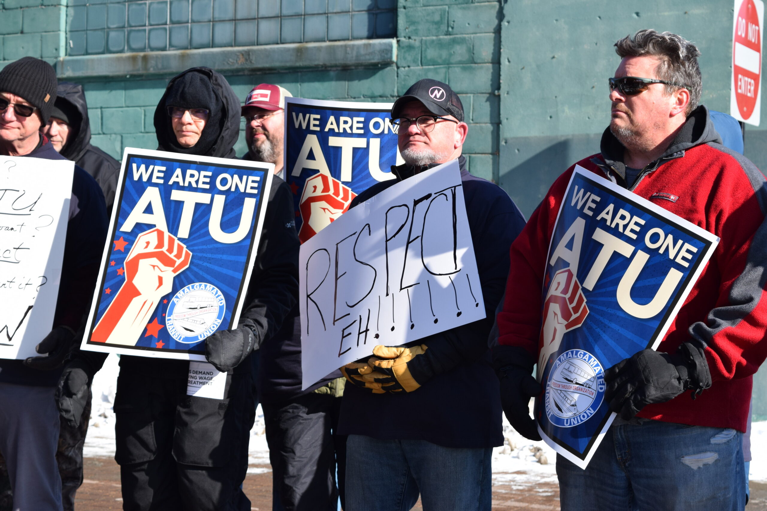 La Crosse bus drivers hold protest signs outside downtown station