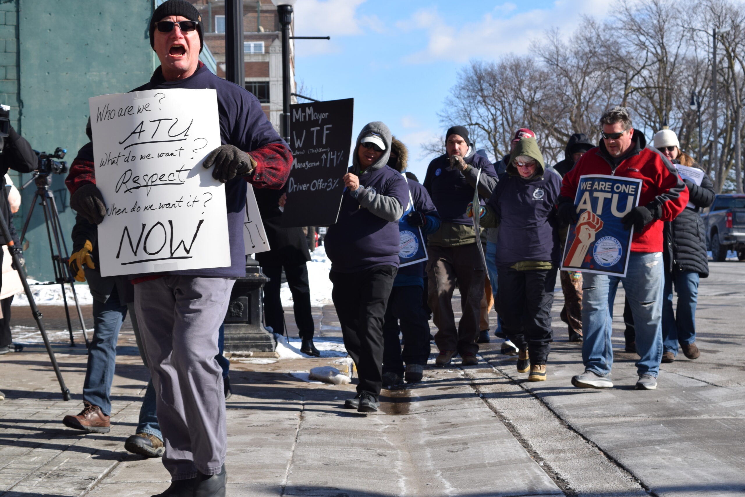 La Crosse bus drivers hold protest signs outside downtown station