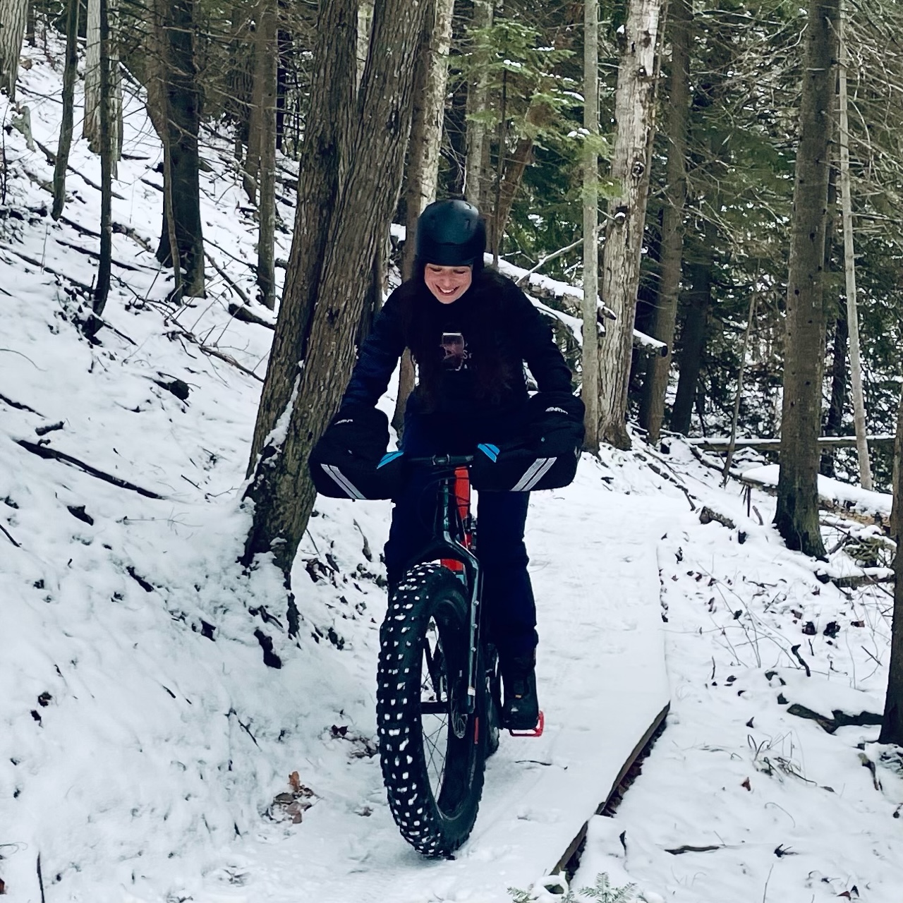 Laura Hrubes rides her fat bike on wooded trails.