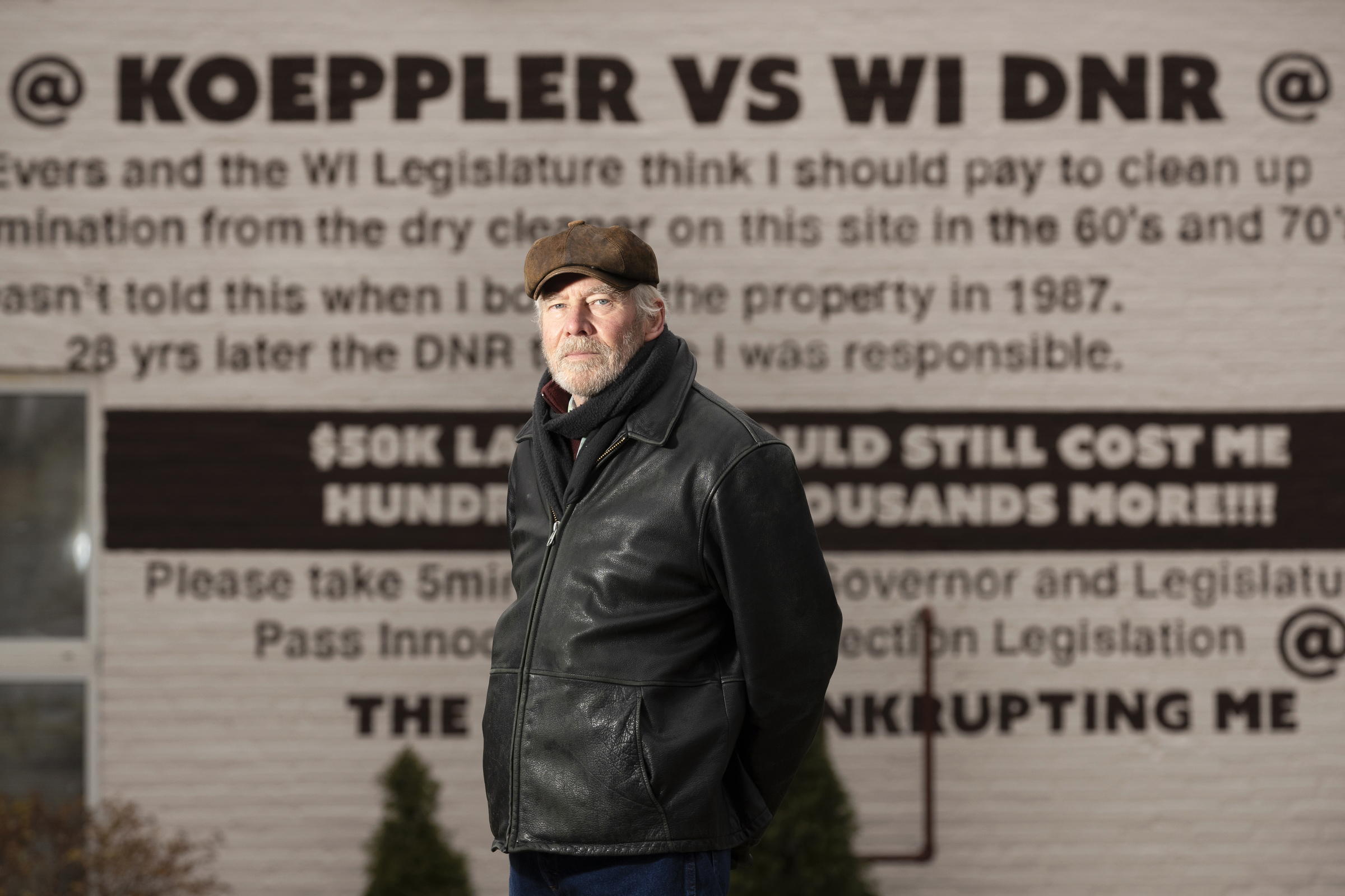 Ken Koeppler poses in a leather jacket and brown hat