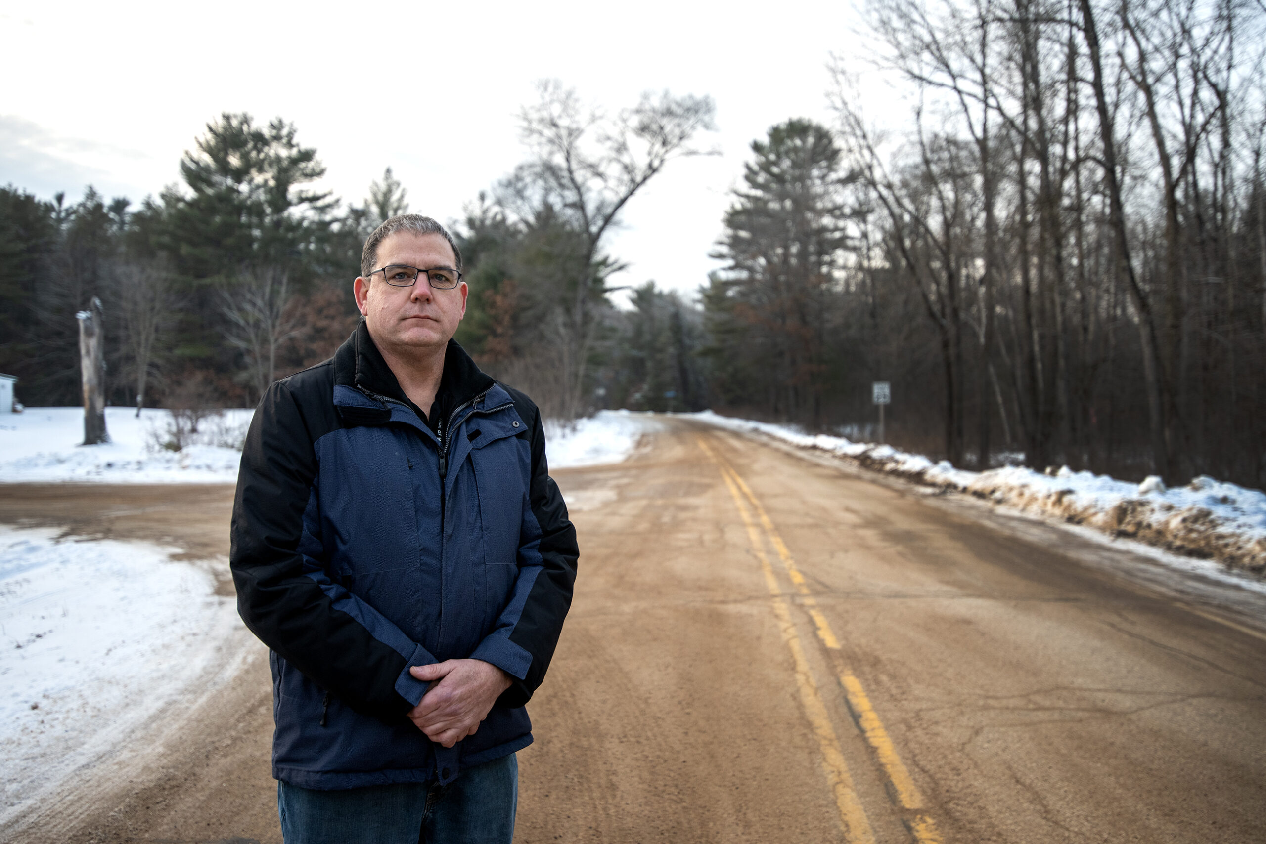 Ben Warrington stands outside on a street.