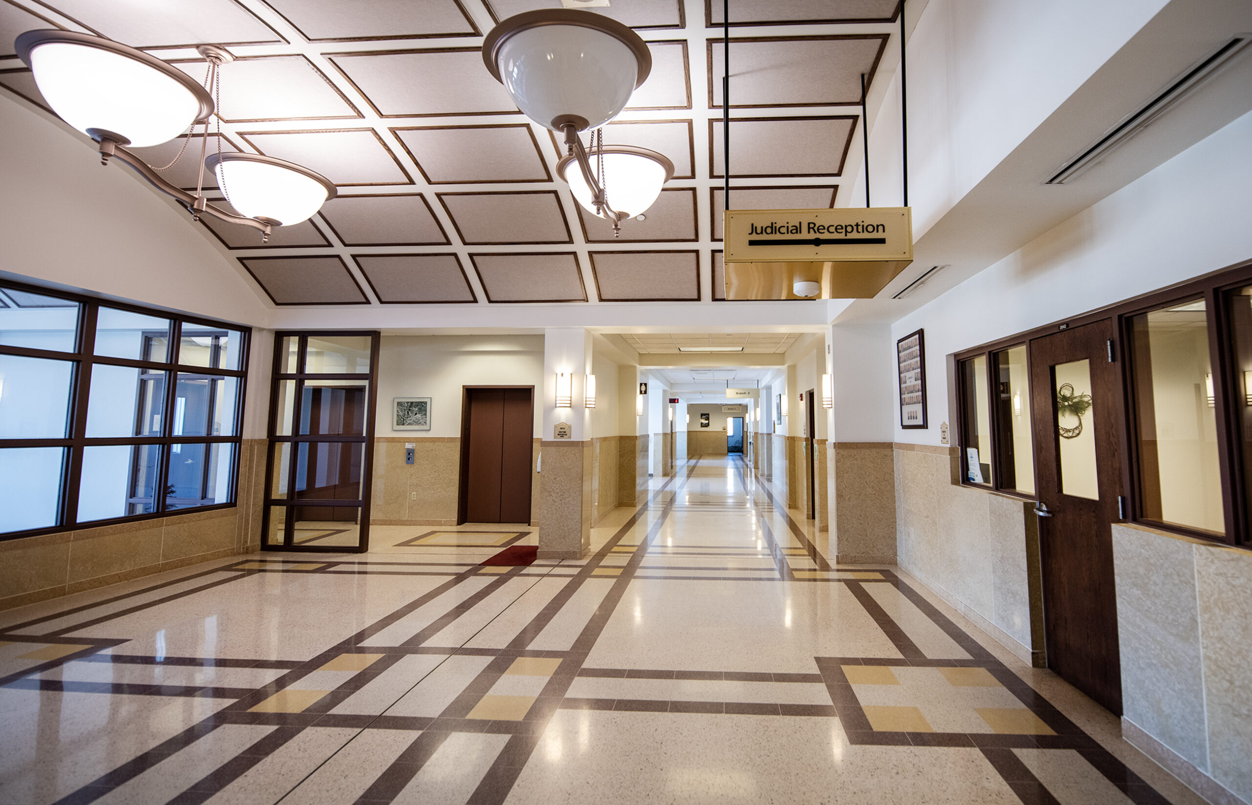 Cream and brown tile in an empty courtroom hallway.