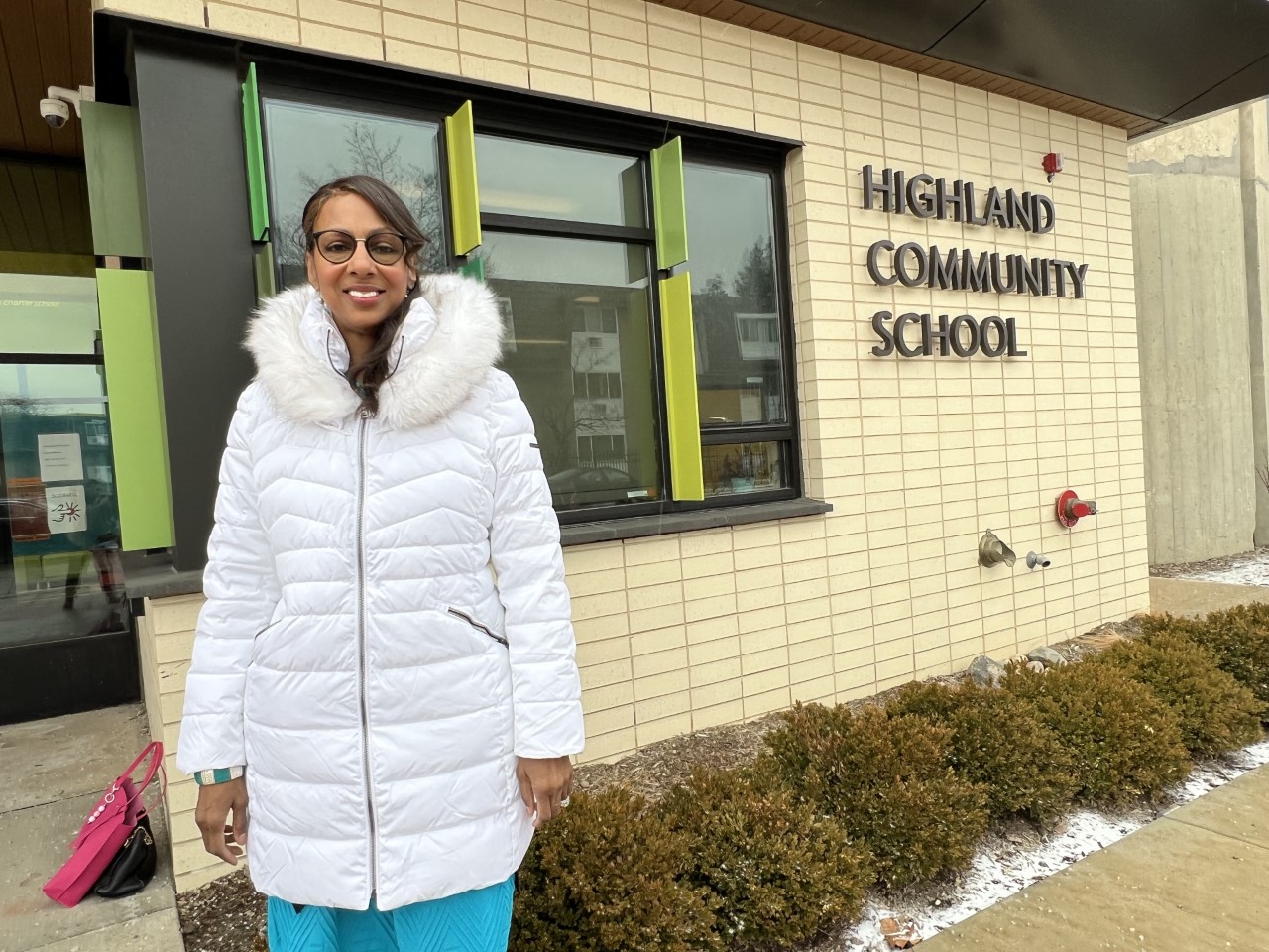 Patricia Cifax Adams poses in front of Highland Community School