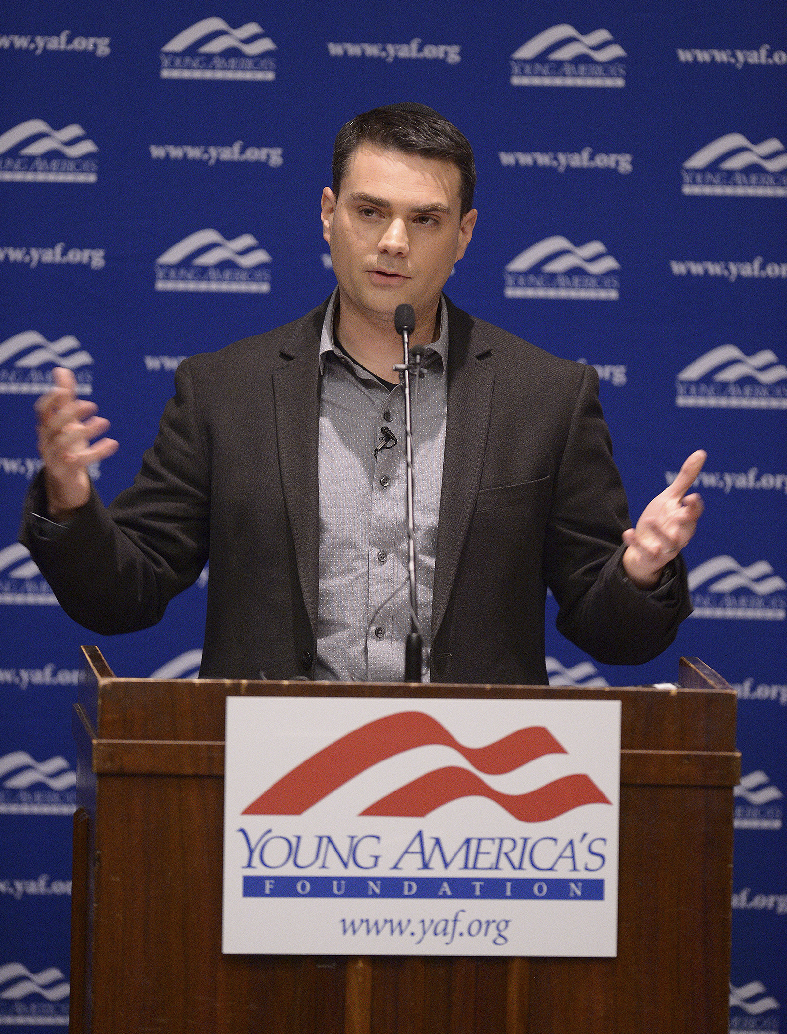 Ben Shapiro speaks at a podium with a sign for the Young Americans for Freedom