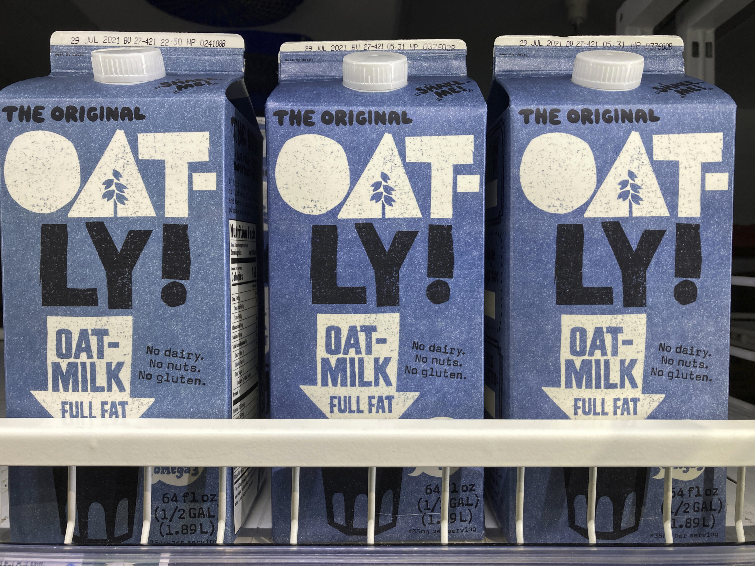 Oatly containers are displayed at a grocery store.