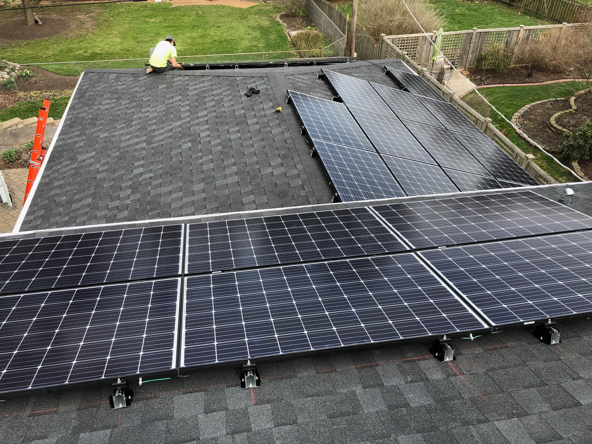 A Sun Badger Solar employee installs solar panels on a home.