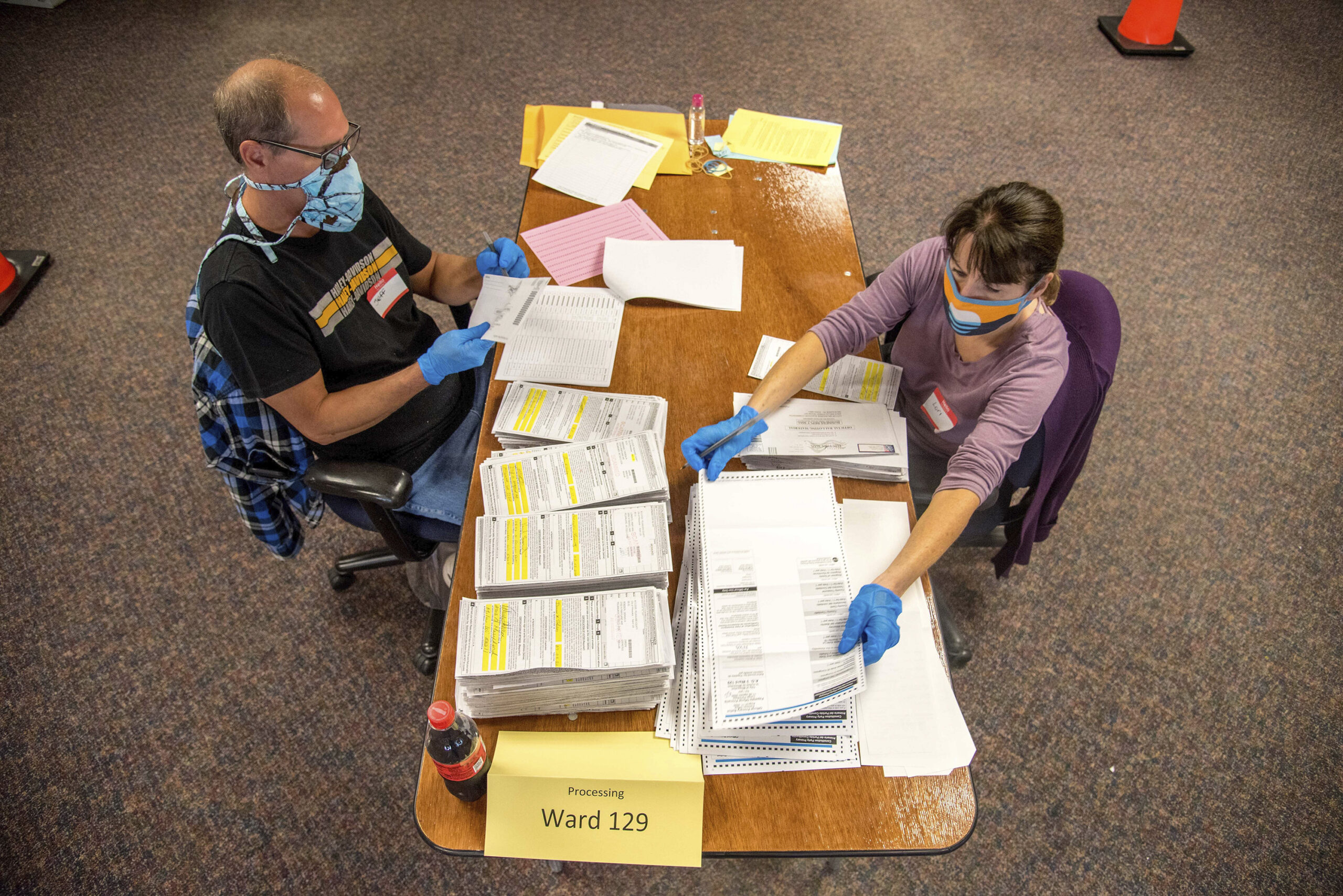 Election workers Jeff and Lori Lutzka, right, process absentee ballots