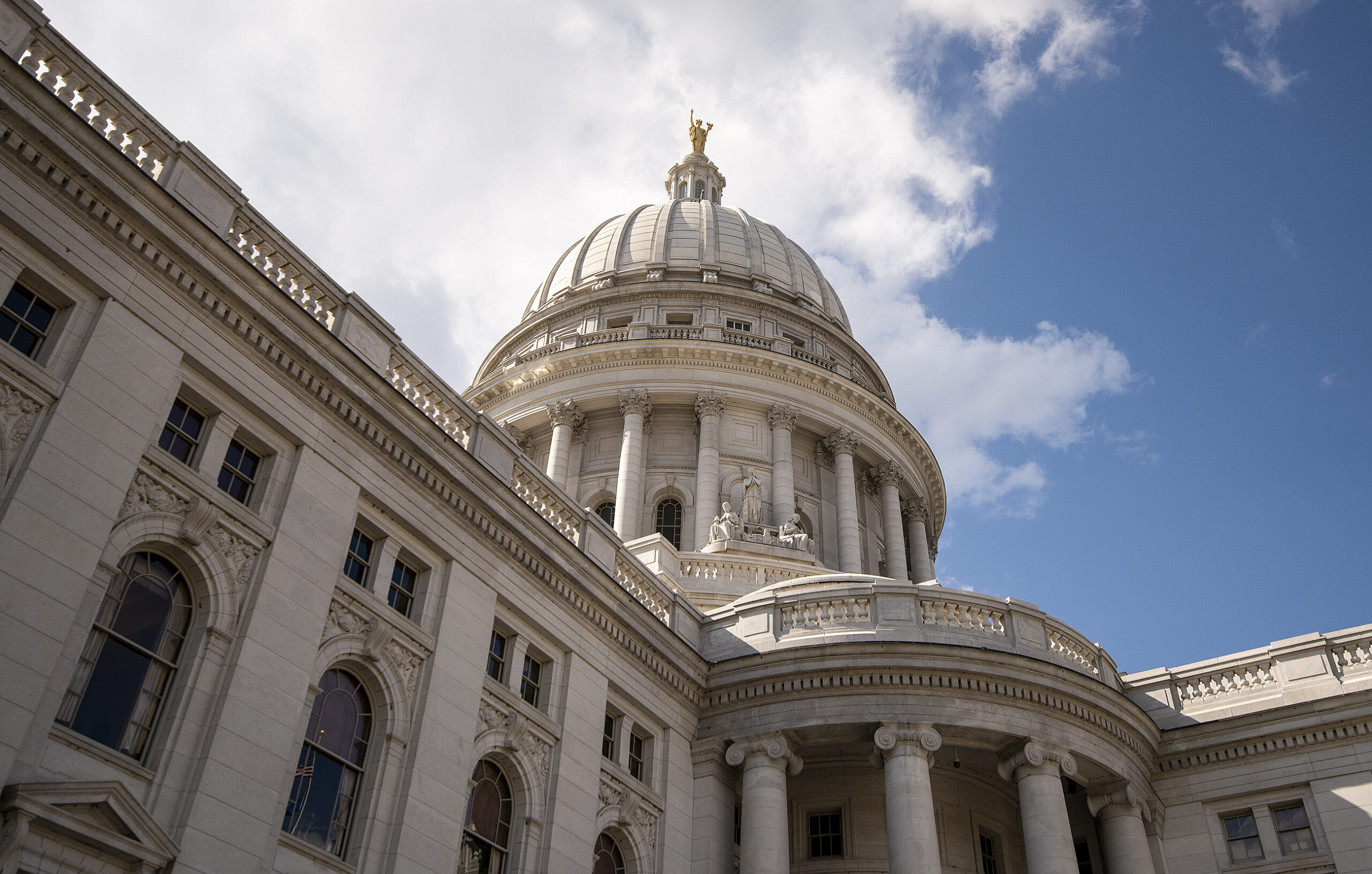 Clouds and a blue sky are seen behind the Wisconsin State Capitol