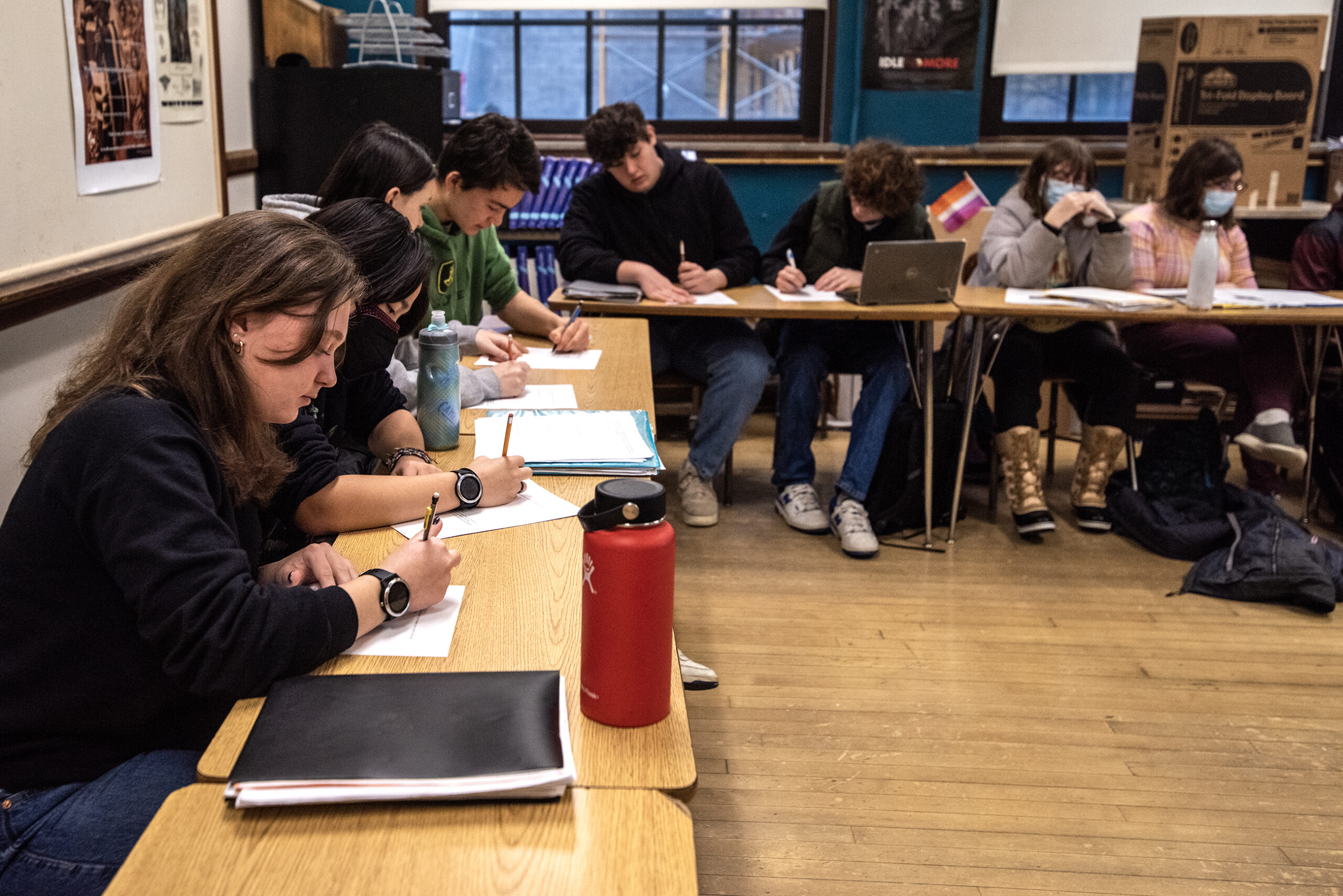 Students sit in desks during a discussion.