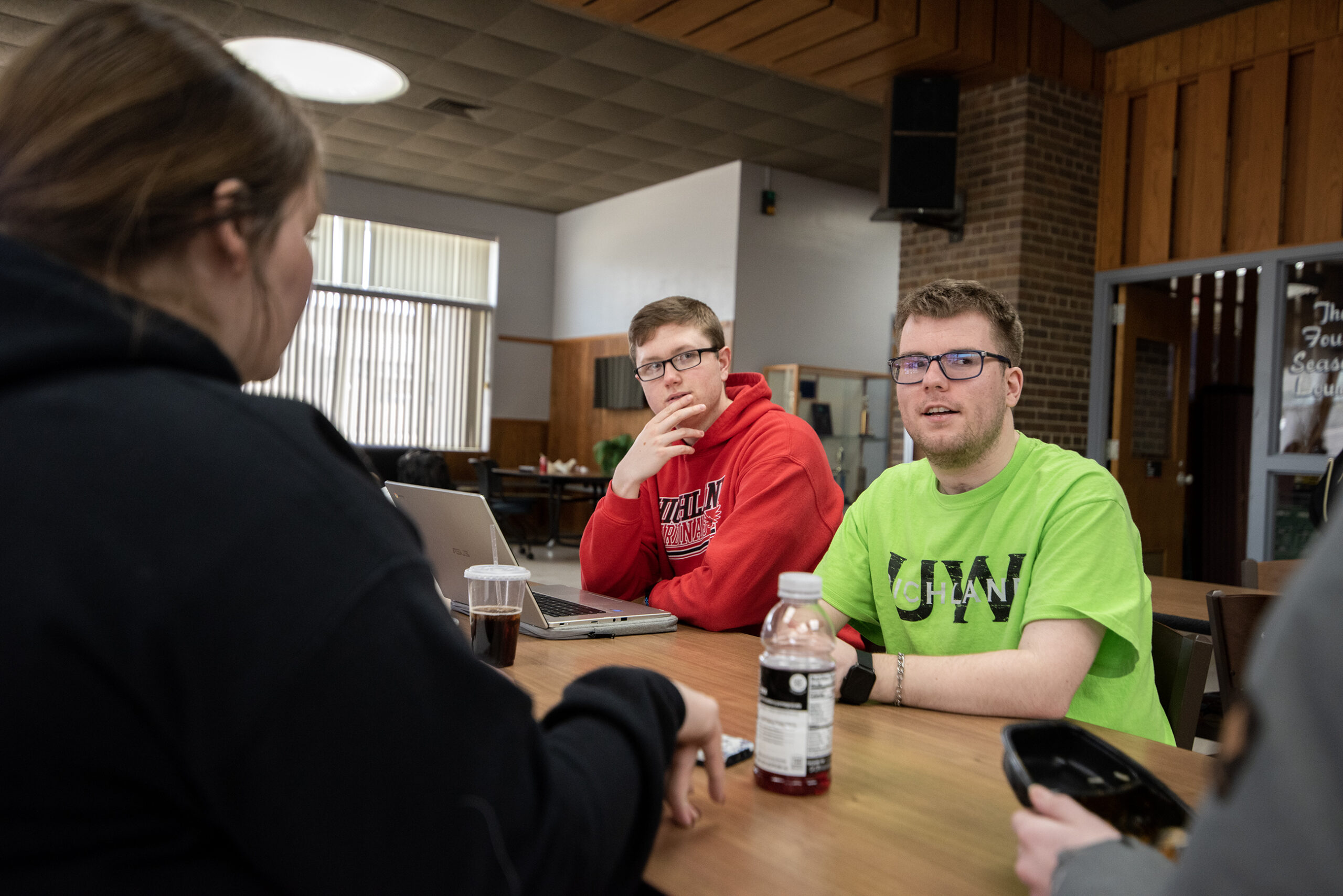 Two students sit together at a table during a discussion.