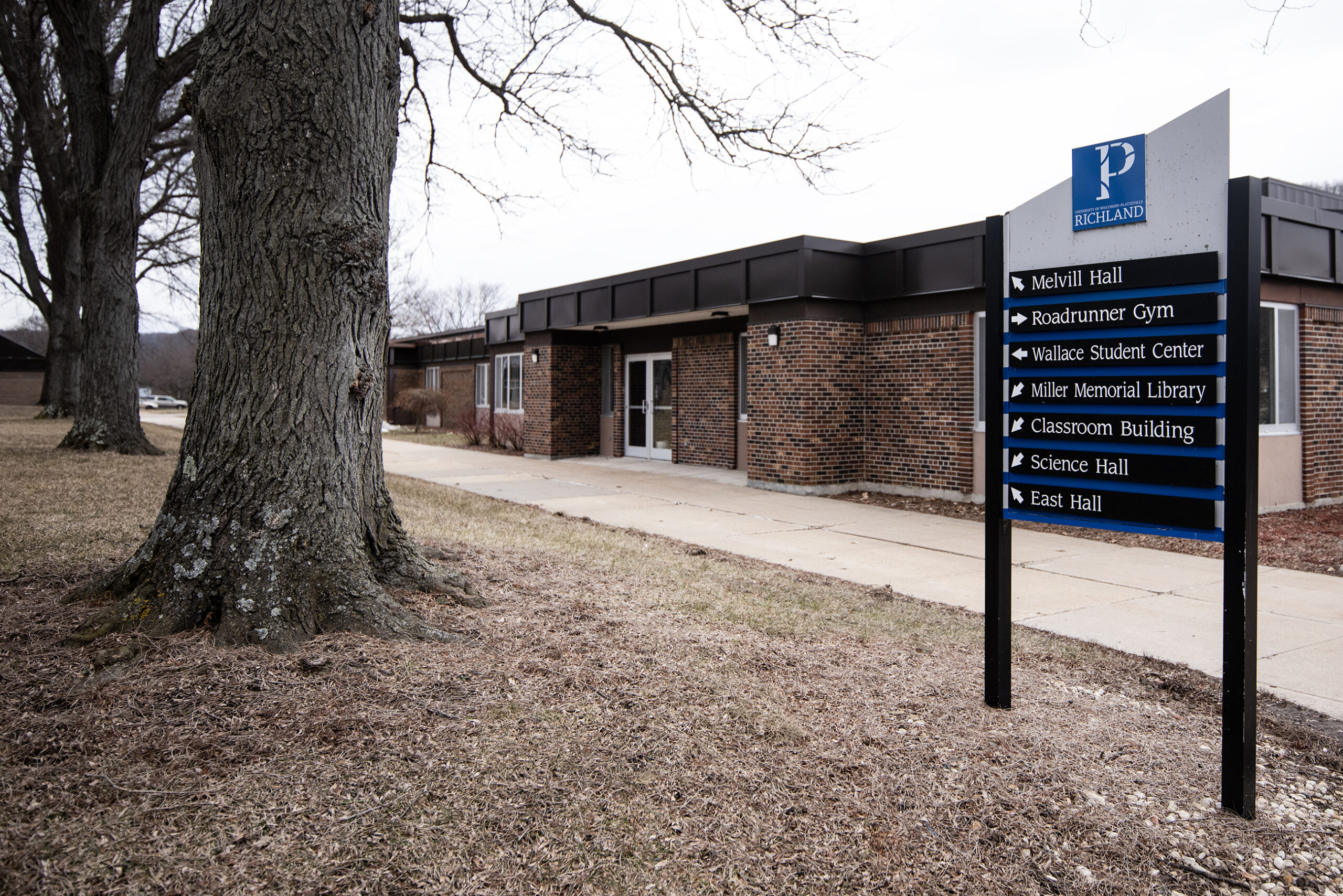 A sign shows building names next to arrows.