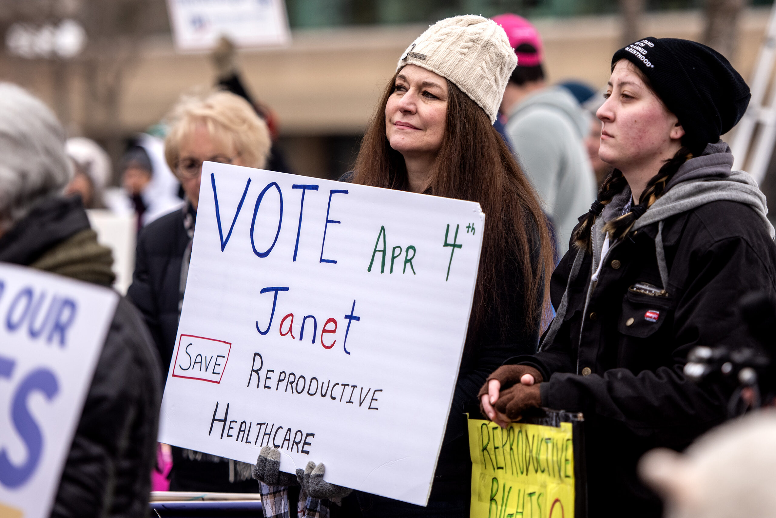 A woman holds a sign that says 