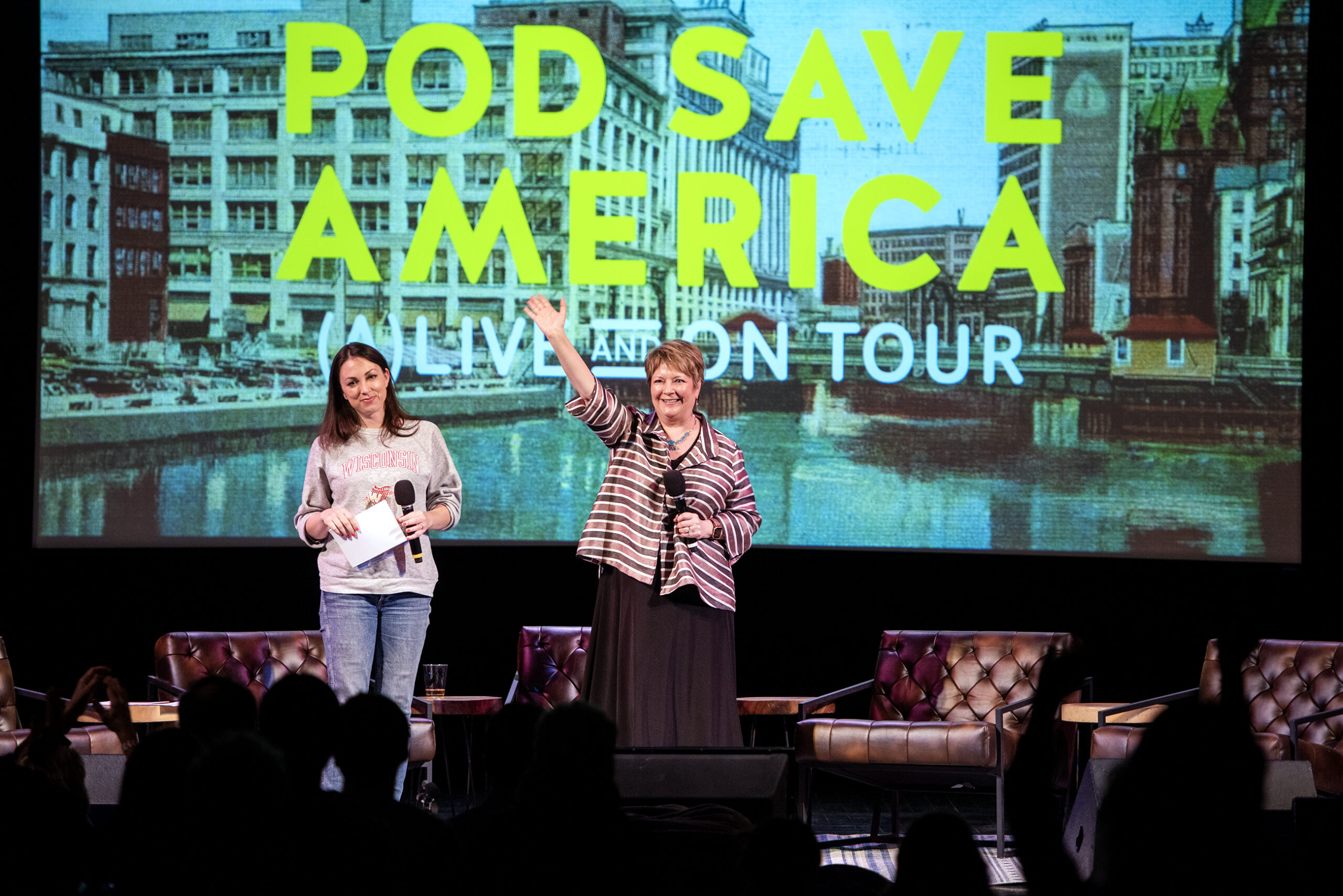 Janet Protasiewicz stands and gives a big wave to the crowd from the stage.