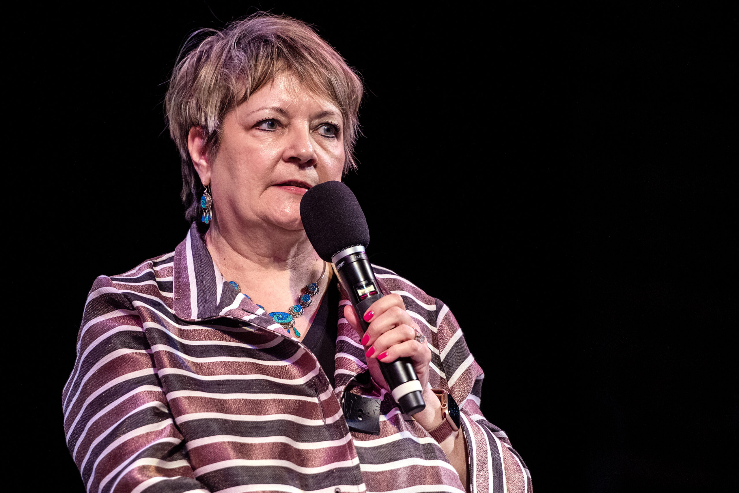 Janet Protasiewicz speaks into a microphone.