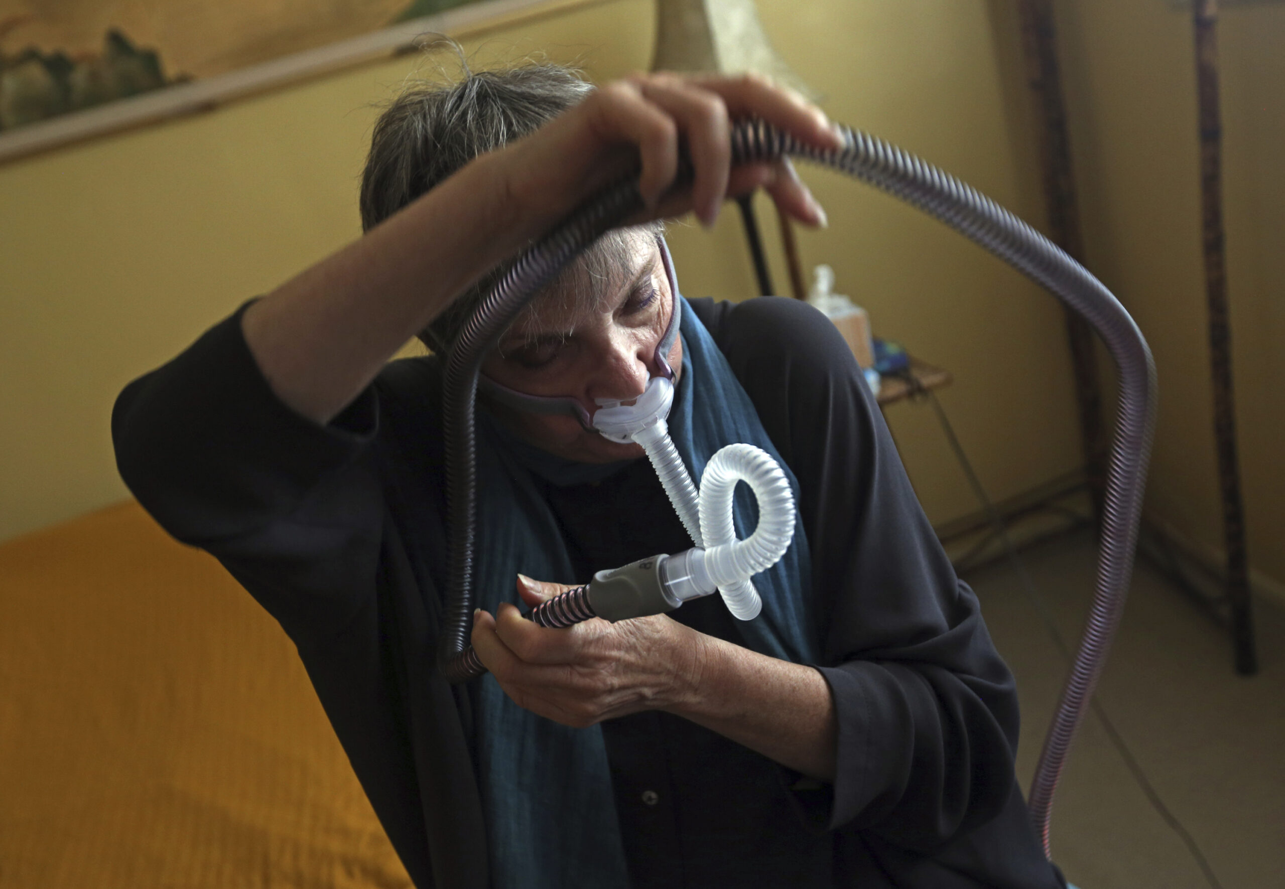 A woman puts on a breathing device