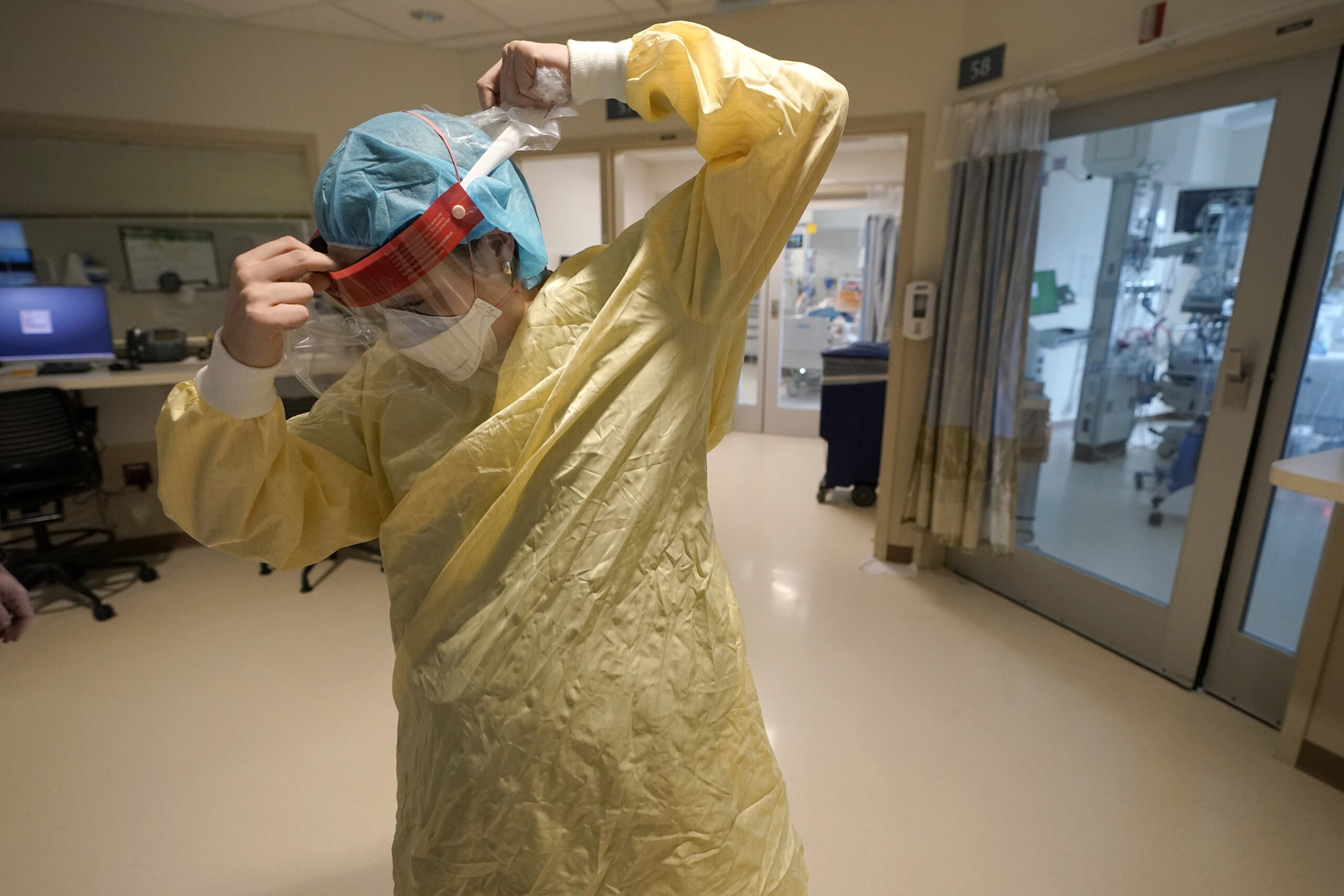 RN Sara Nystrom prepares to enter a patient's room in the COVID-19 Intensive Care Unit