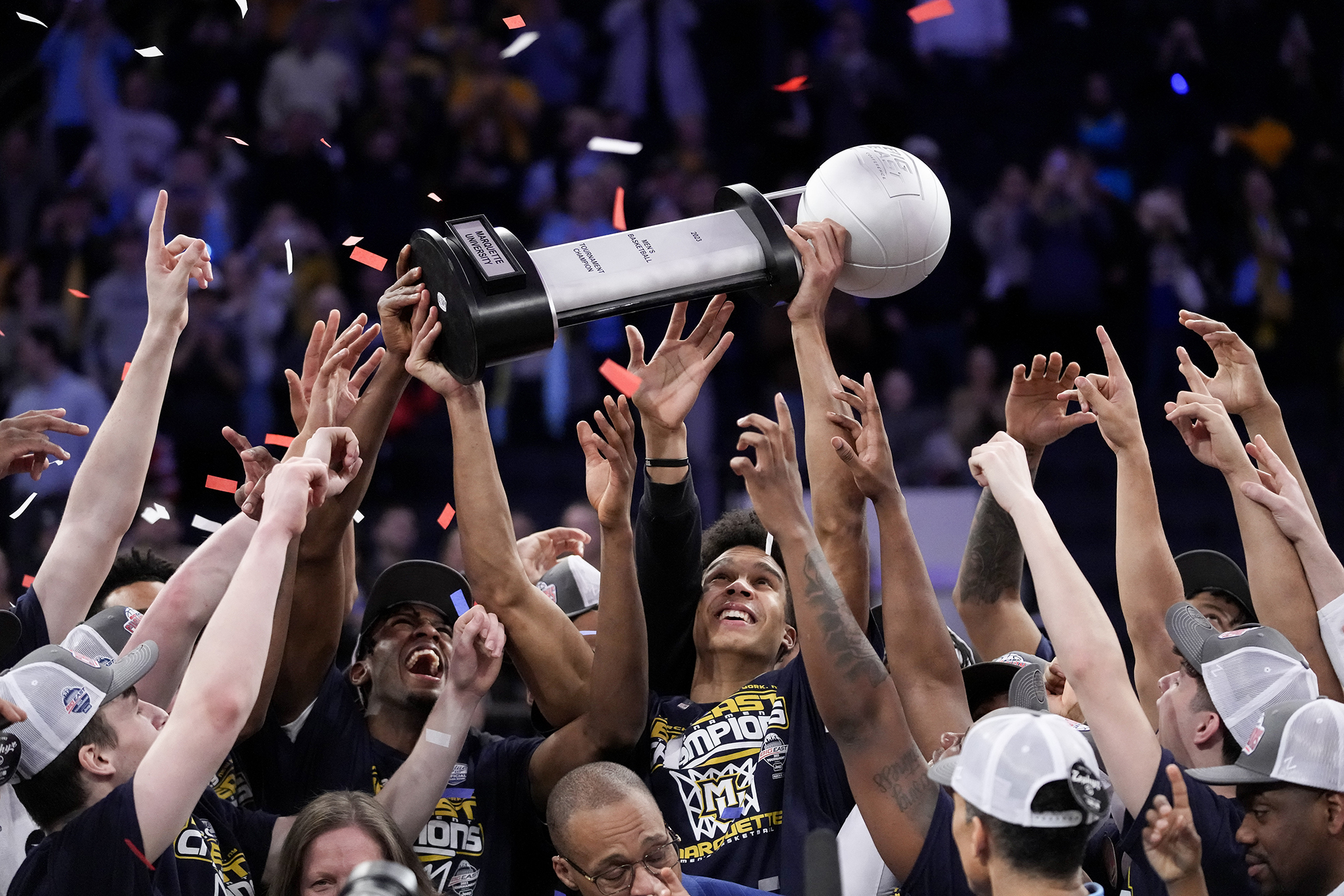 Marquette players and staff hold the championship trophy.