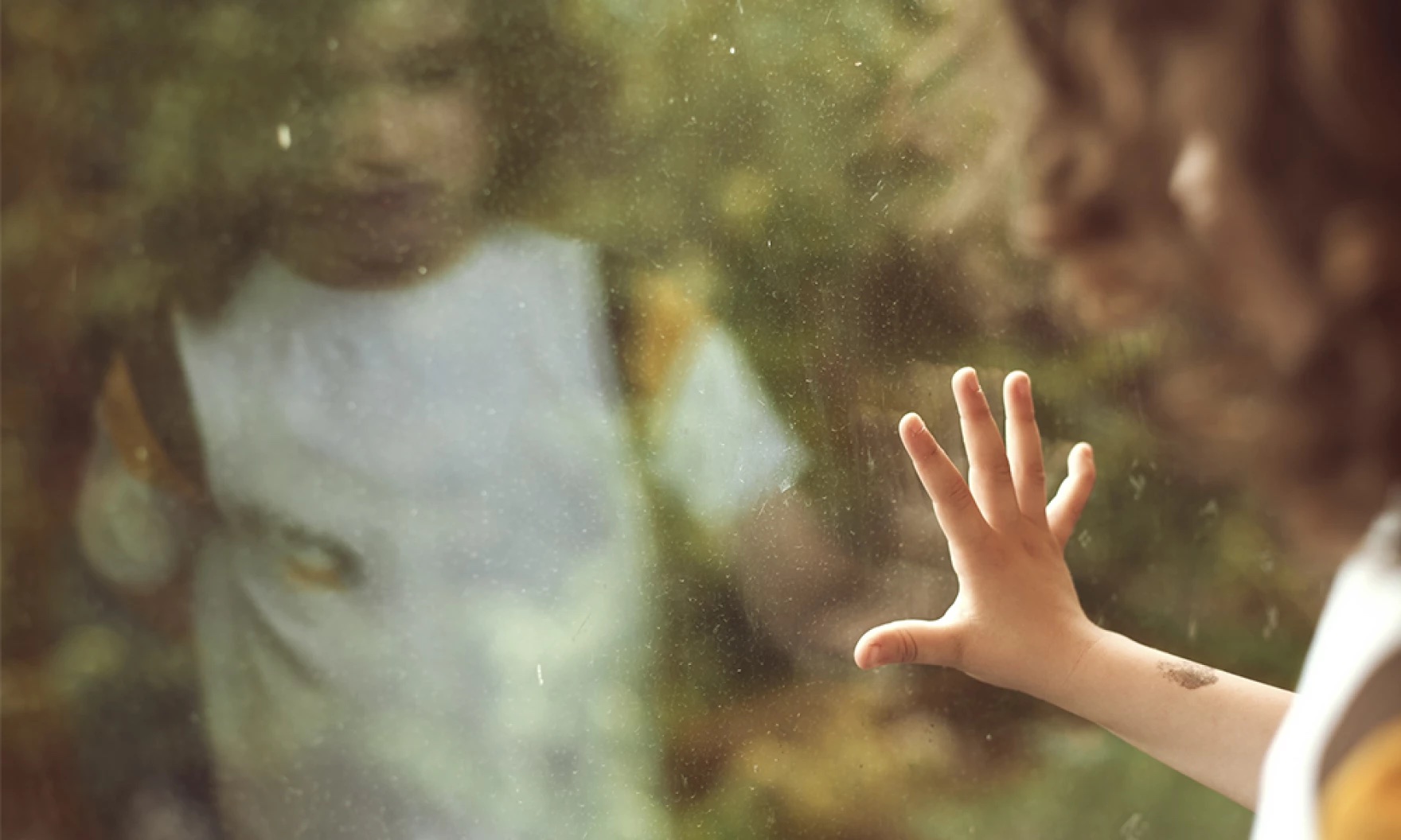 A child places hand on window.