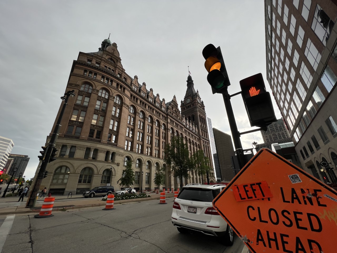 Milwaukee City Hall is seen off a street with a "left lane closed" sign