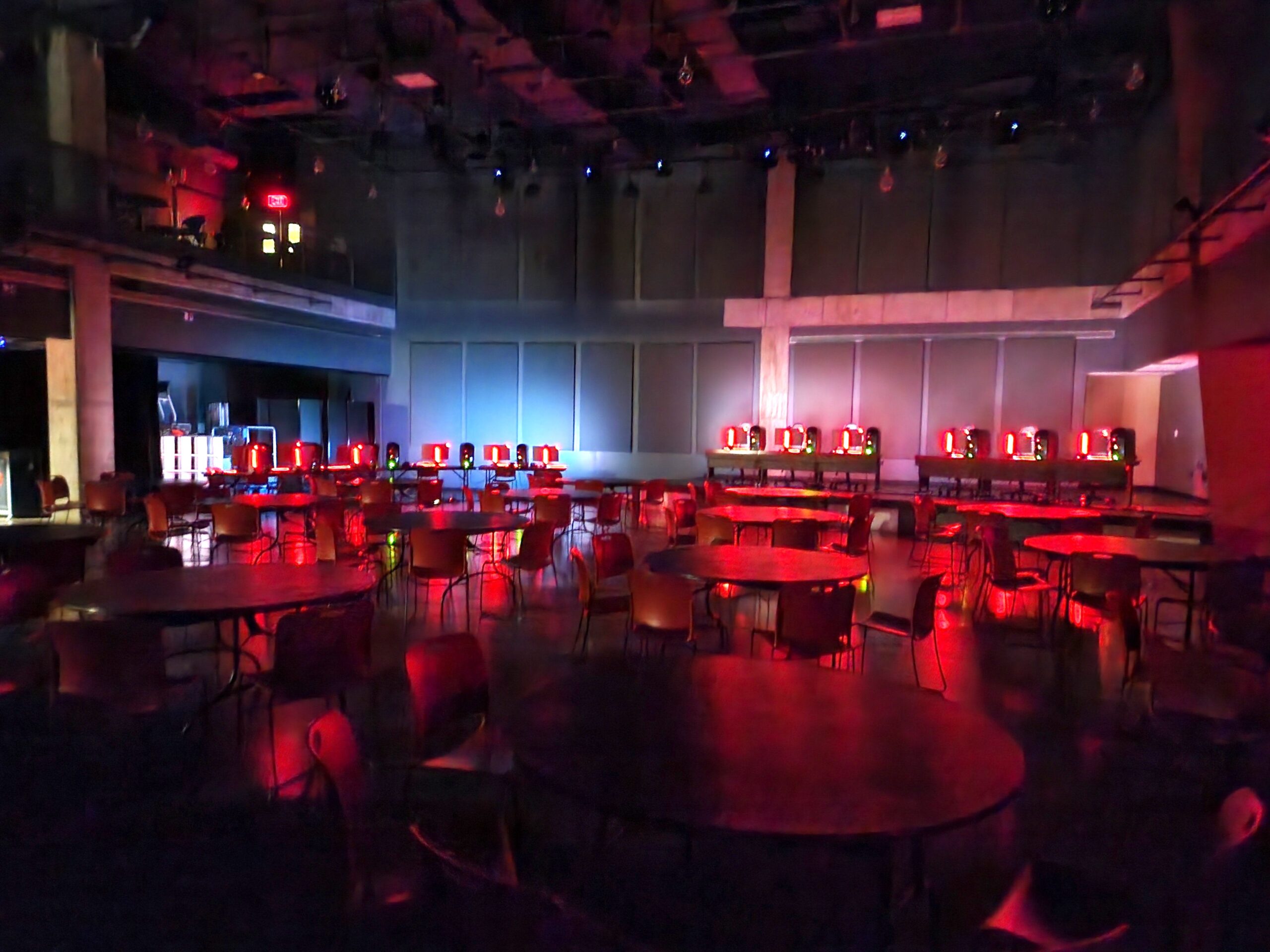 A room is lit red with empty chairs set up for the Wisconsin High School Esports Association winter championship