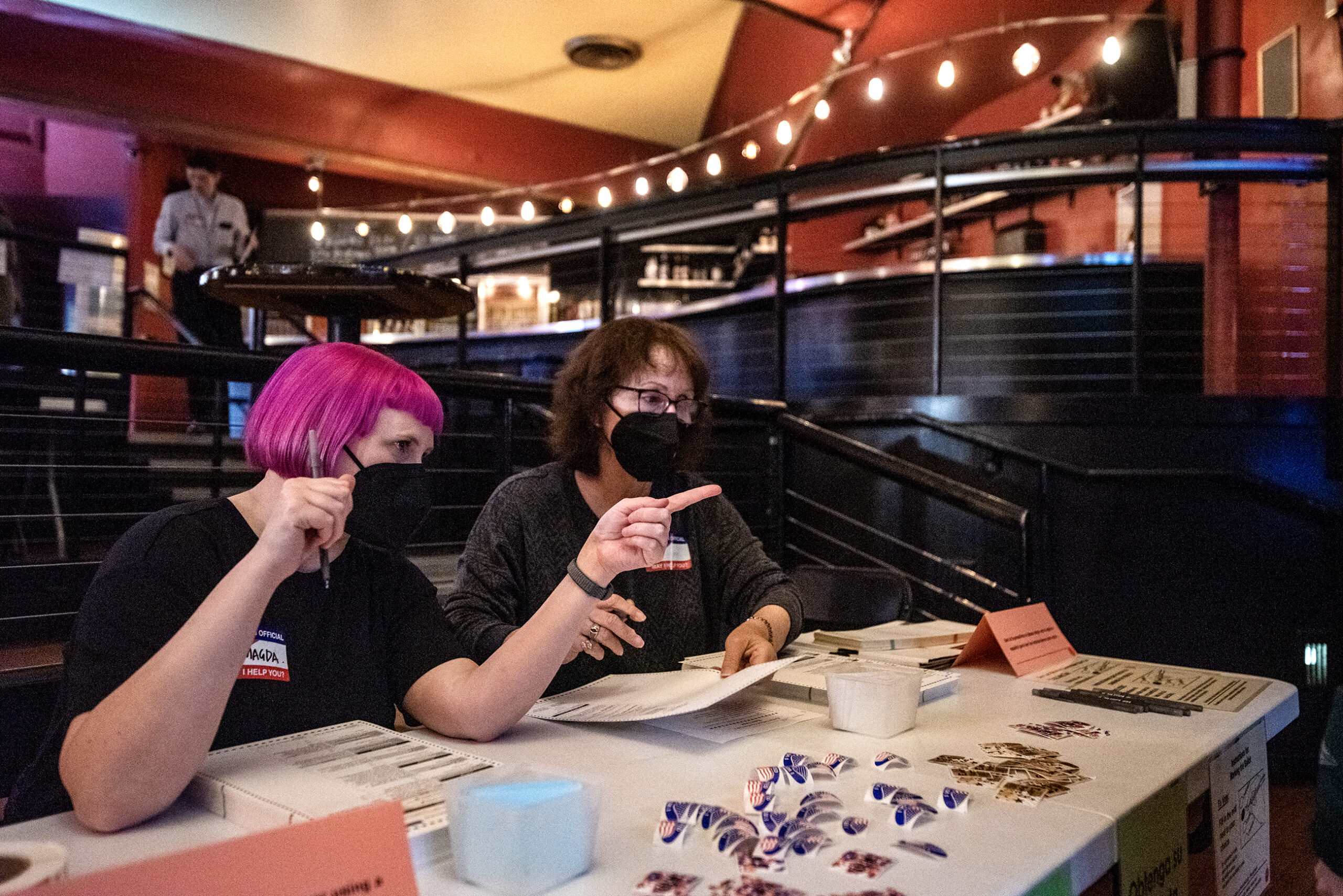 Two workers sit at a table inside a theater.