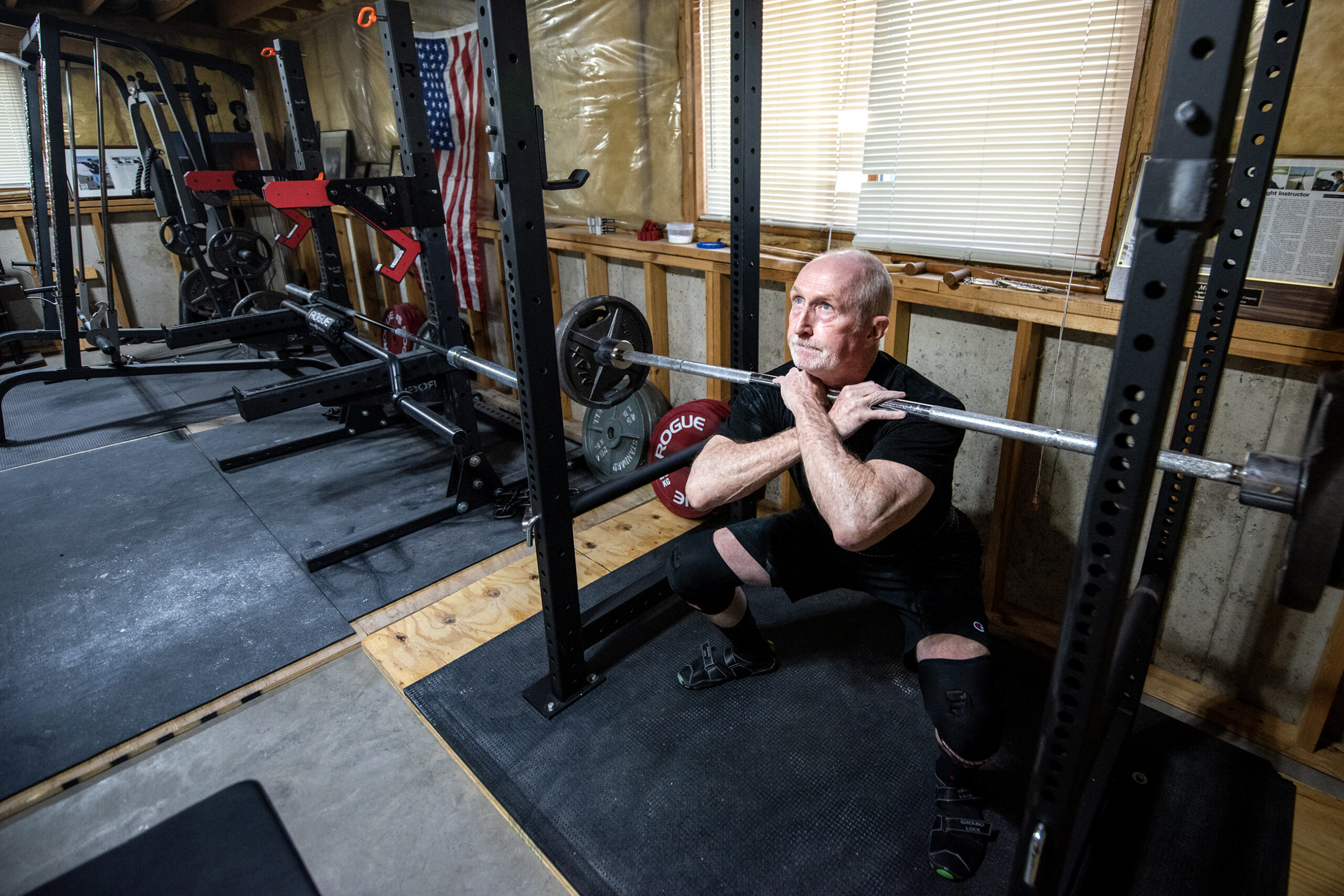 Michael Love crosses his arms as he lifts the weights with his chest.