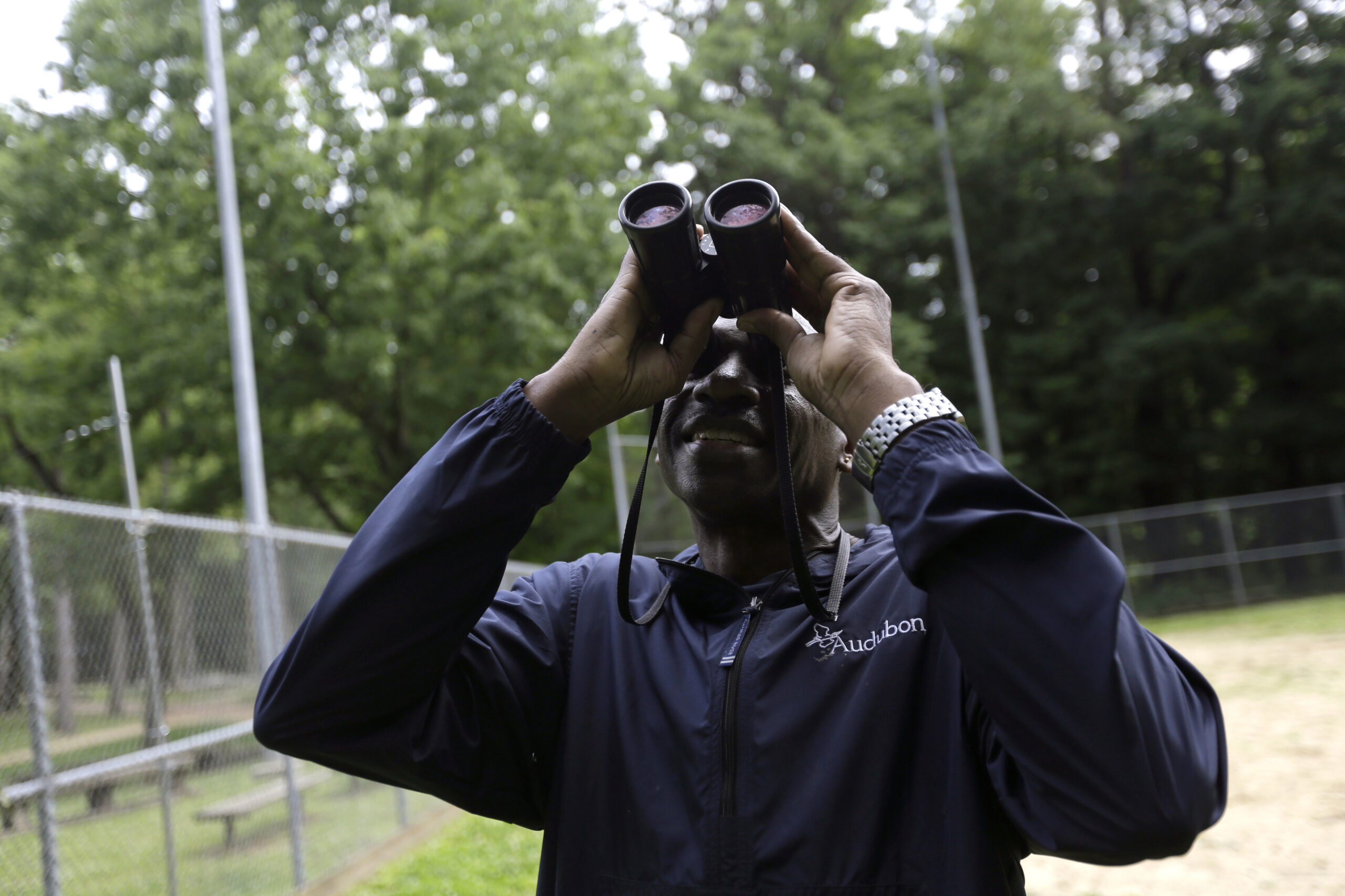 Keith Russell looks through binoculars while conducting a breeding bird census.