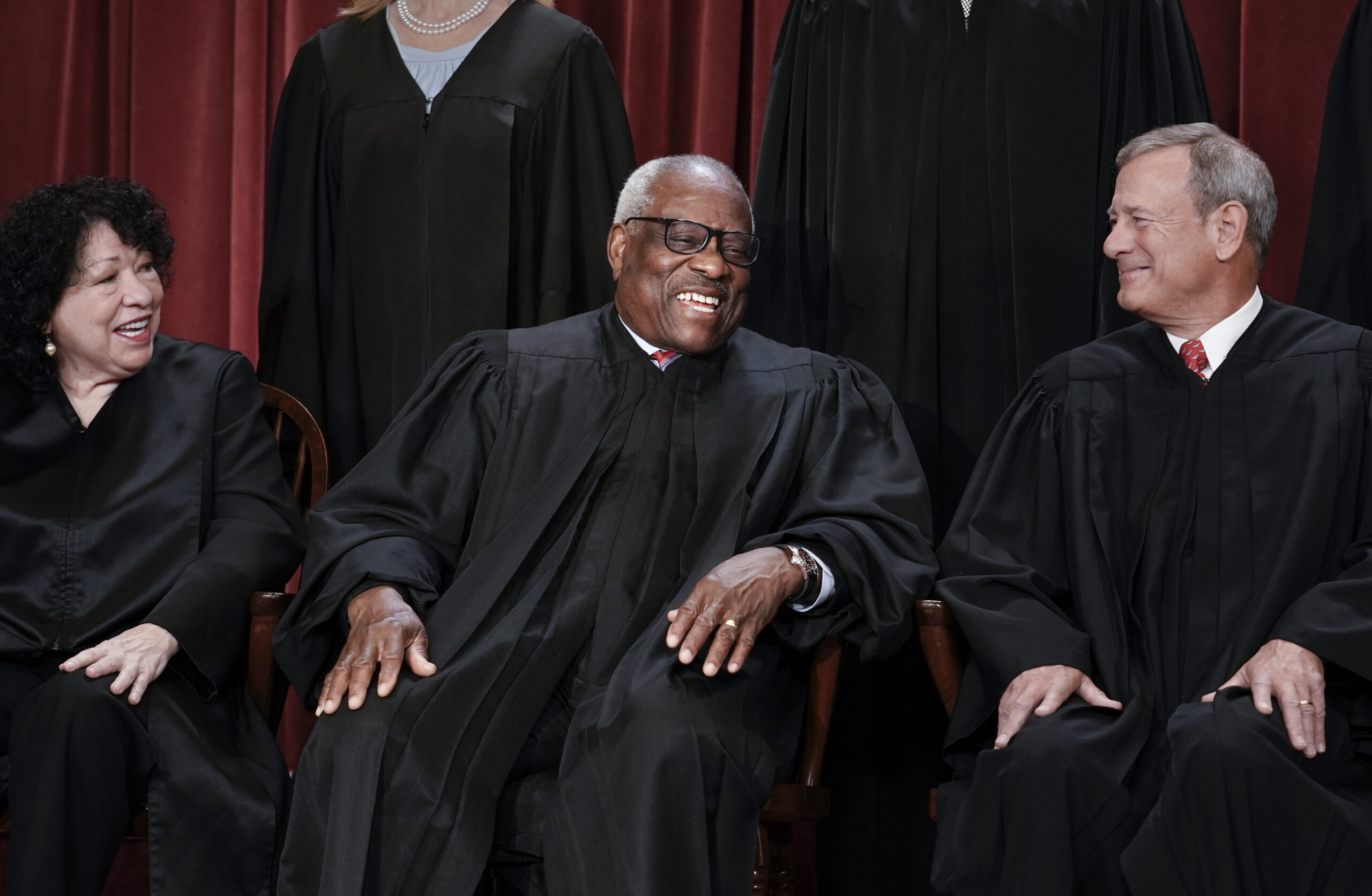 Associate Justice Clarence Thomas, center, is flanked by Associate Justice Sonia Sotomayor, left, and Chief Justice of the United States John Roberts.