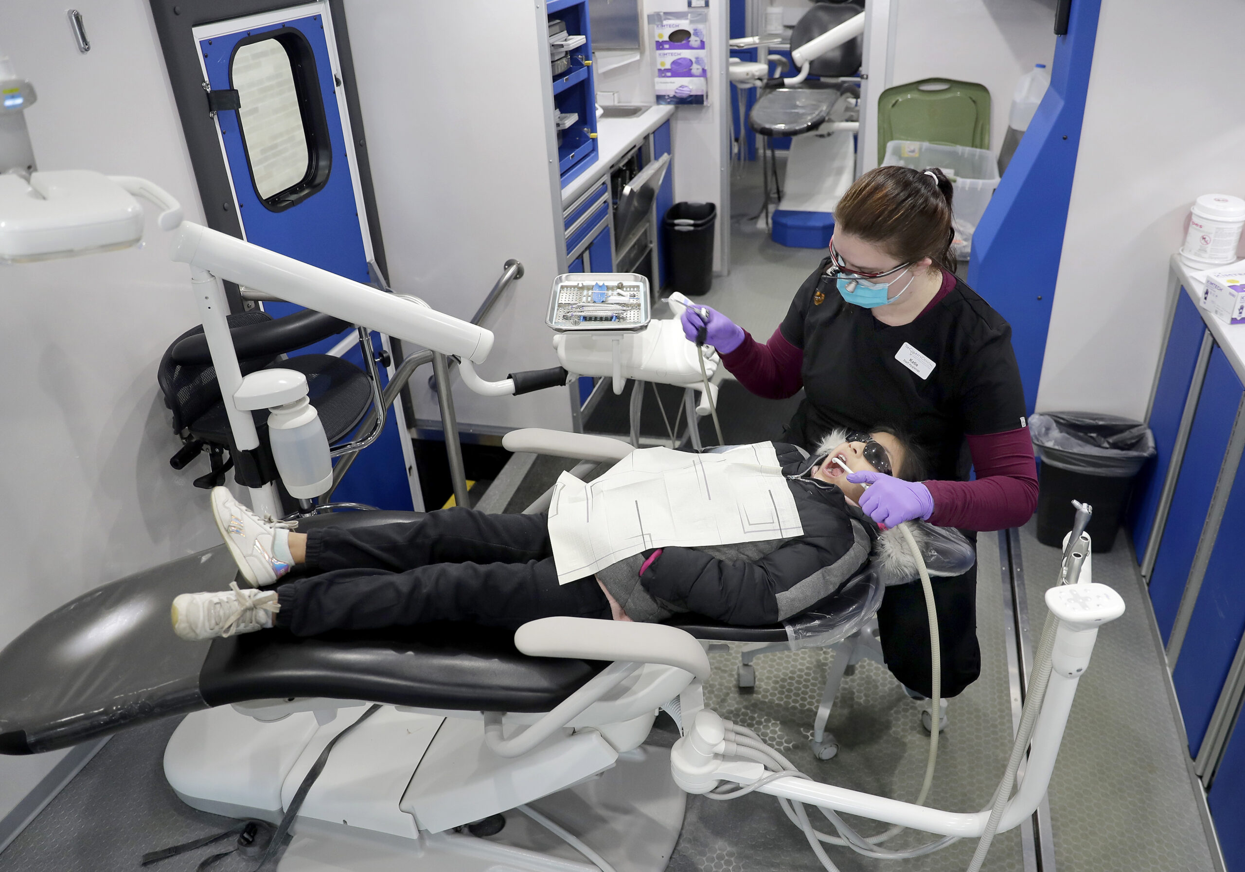Hygienist Katie Wheeler cleans Sarahi Dominguez Rodriguez's teeth during a Tri-County Dental mobile clinic