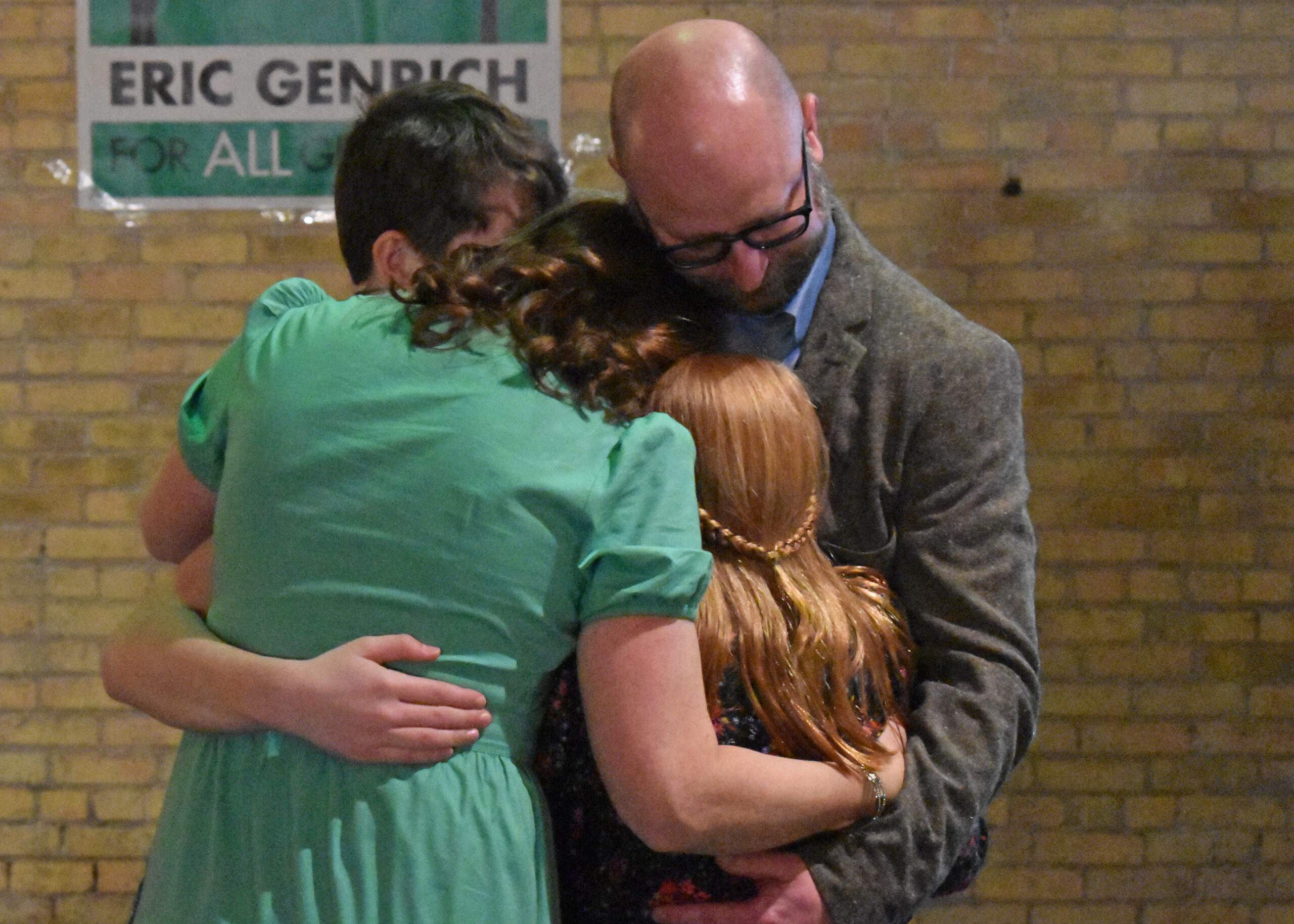 Mayor Eric Genrich and his family embrace after he delivered a victory speech at Gather on Broadway in Green Bay Tuesday night