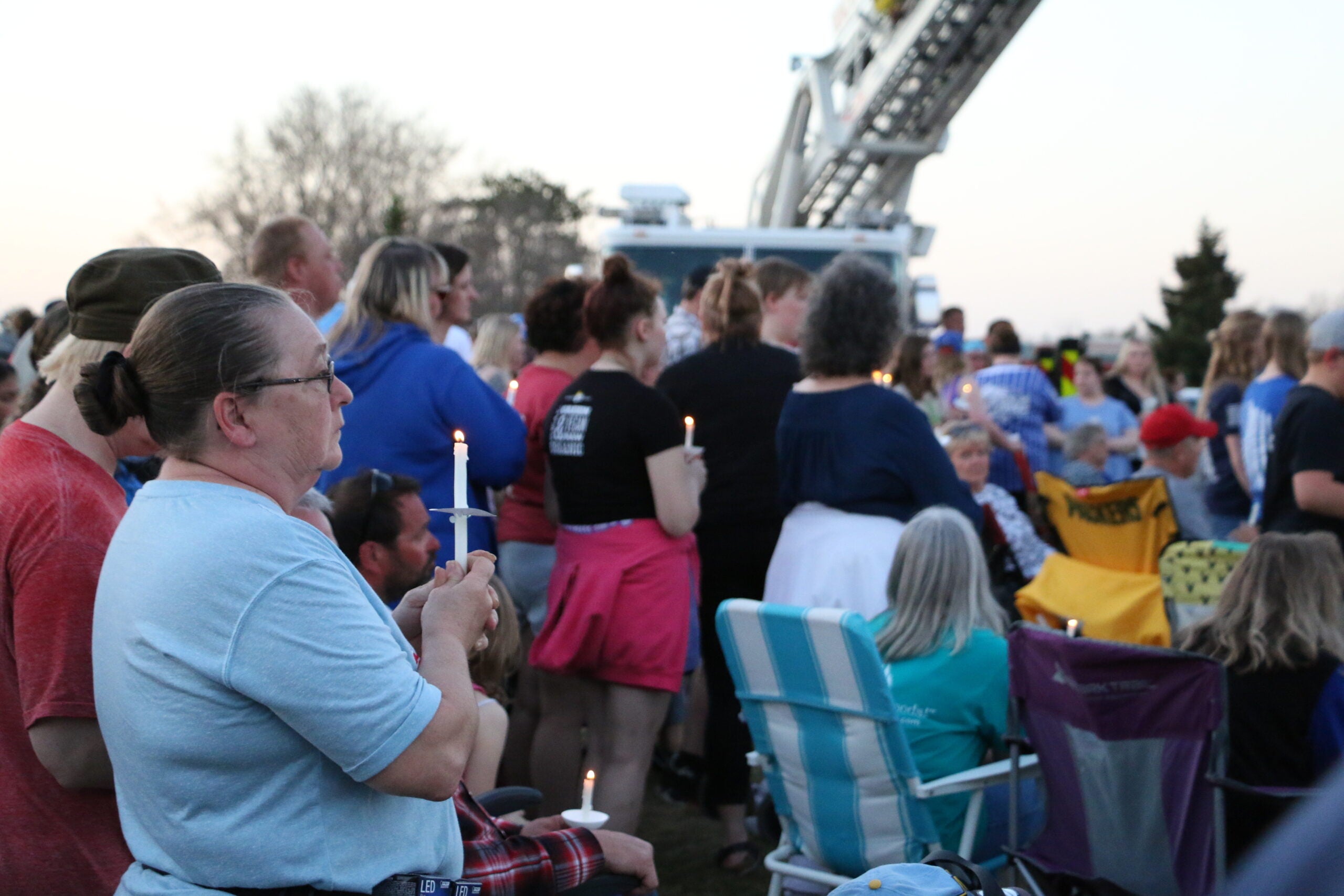 Vigil attendees hold candles as they mourn police officers from the small towns of Cameron and Chetek