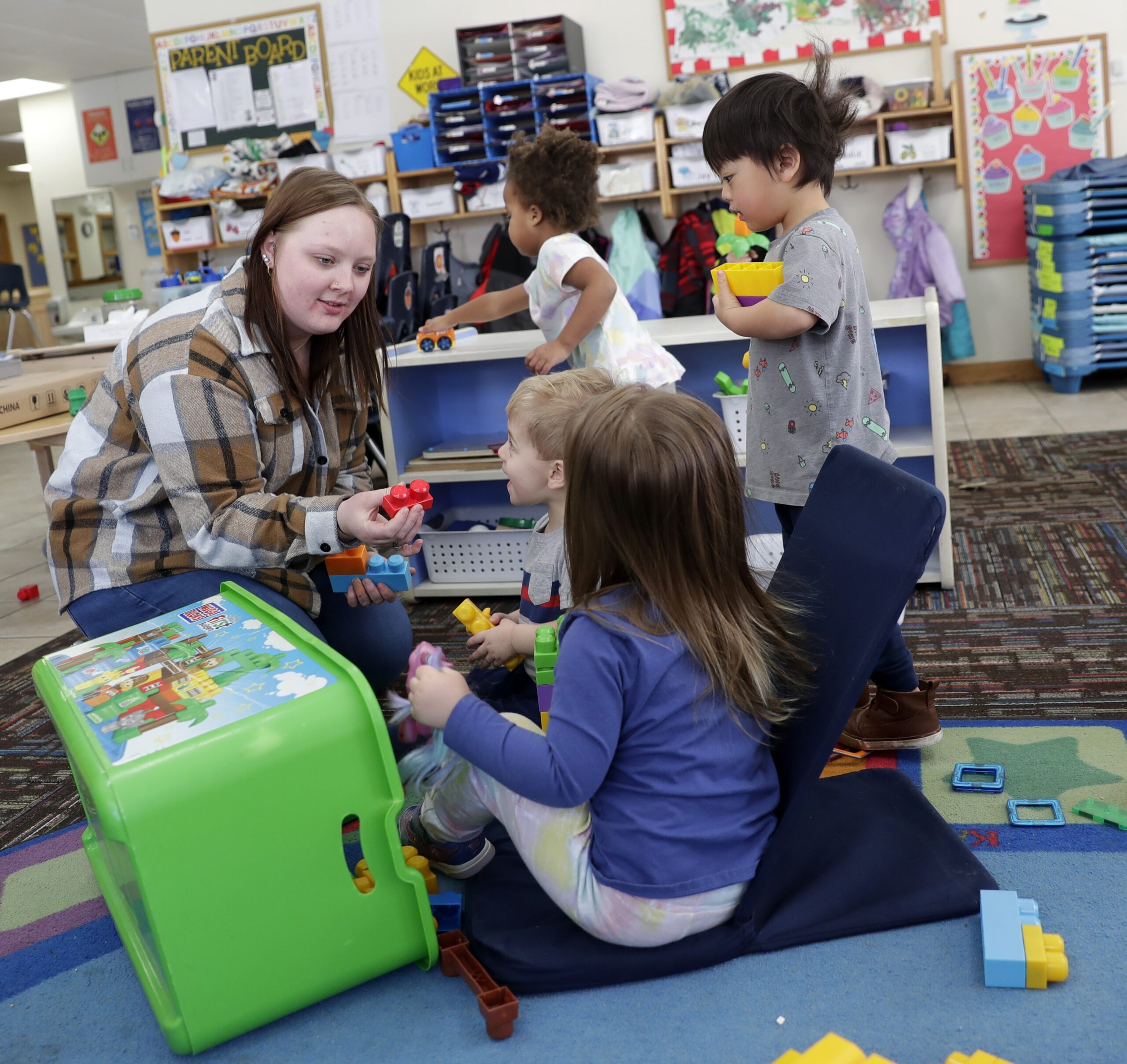 A teacher plays with young students in a classroom