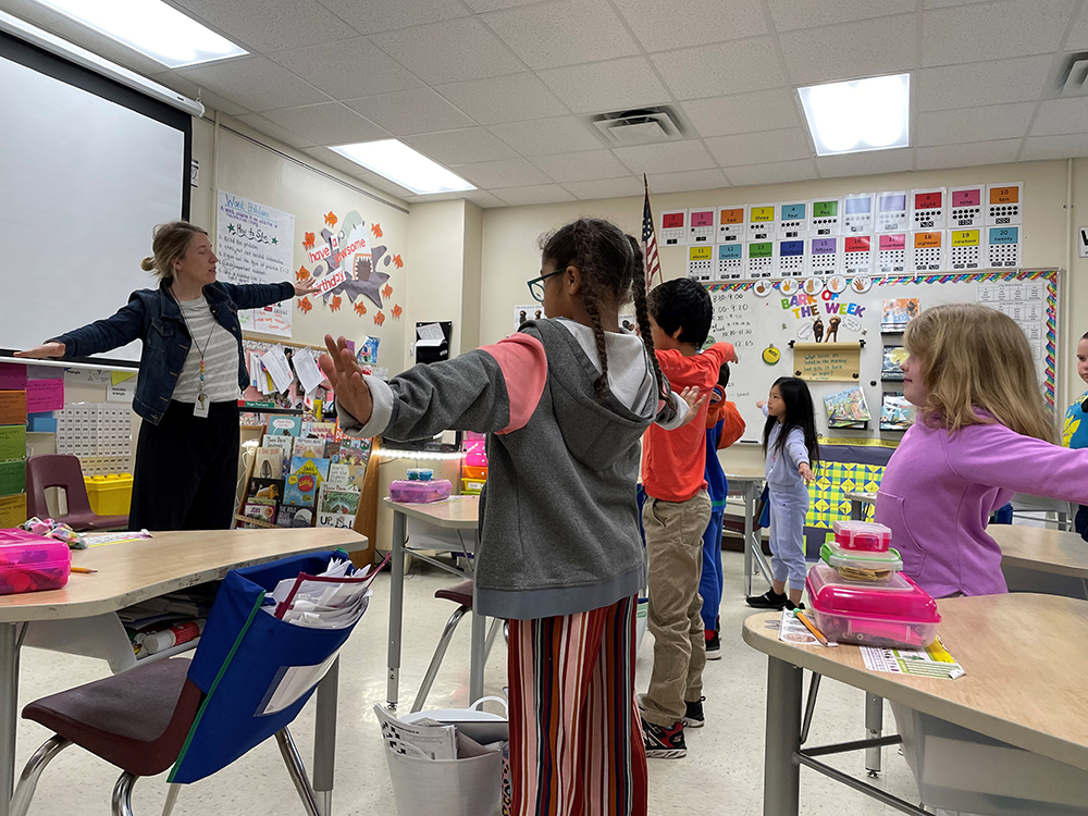 Fourth-graders fan their arms in a big stretch as part of mindfulness at Tank Elementary School in Green Bay