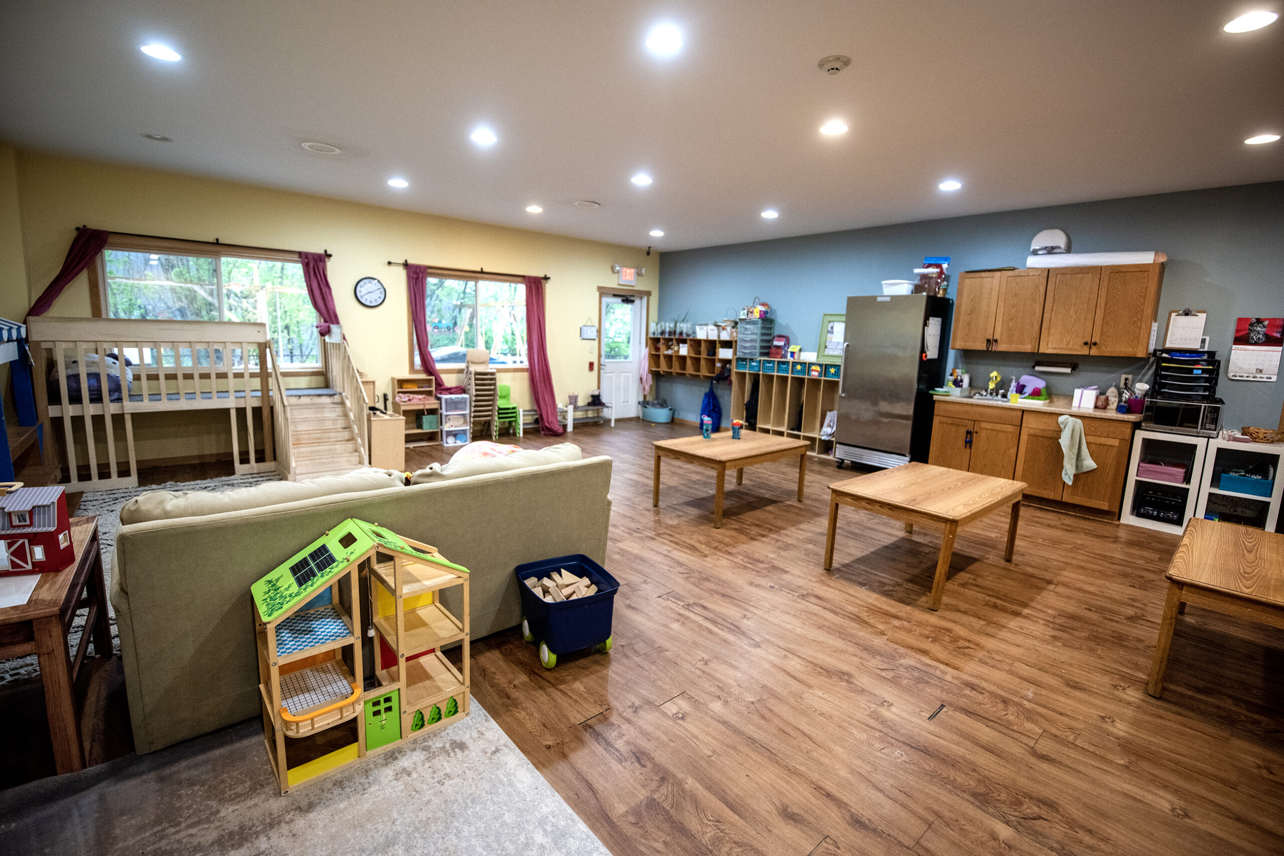 tables, toys, and other supplies are set up in a children's classroom.