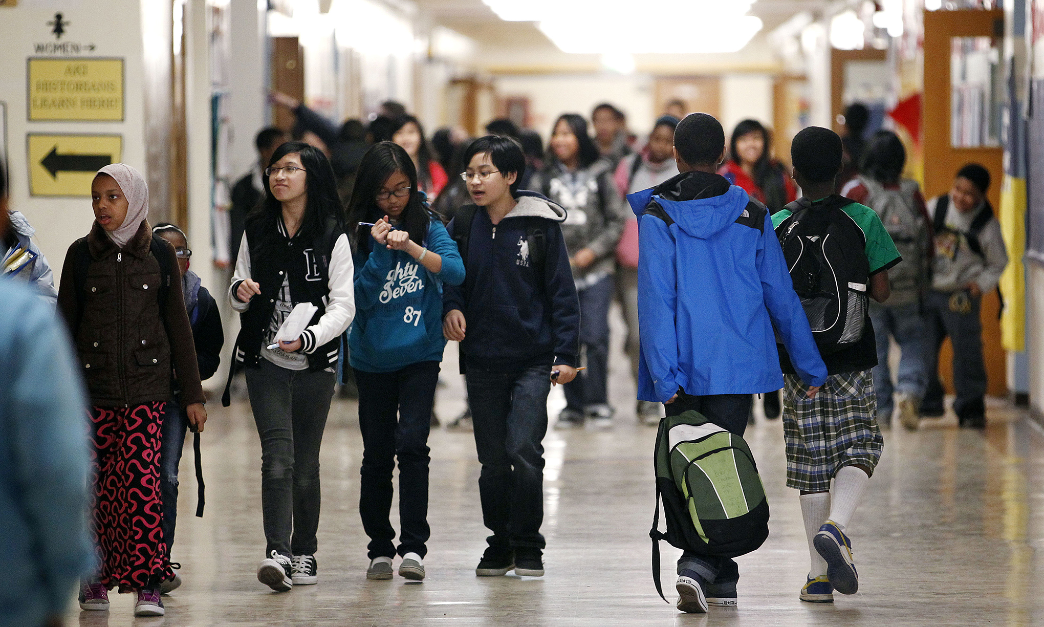 Students walk in the hallway of their middle school between classes.