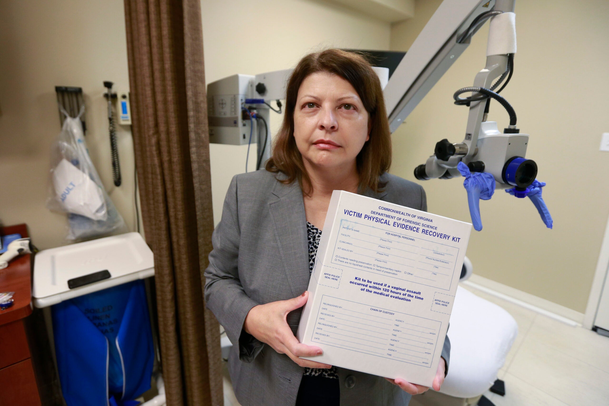 An educator holds a sexual assault evidence kit in an exam room