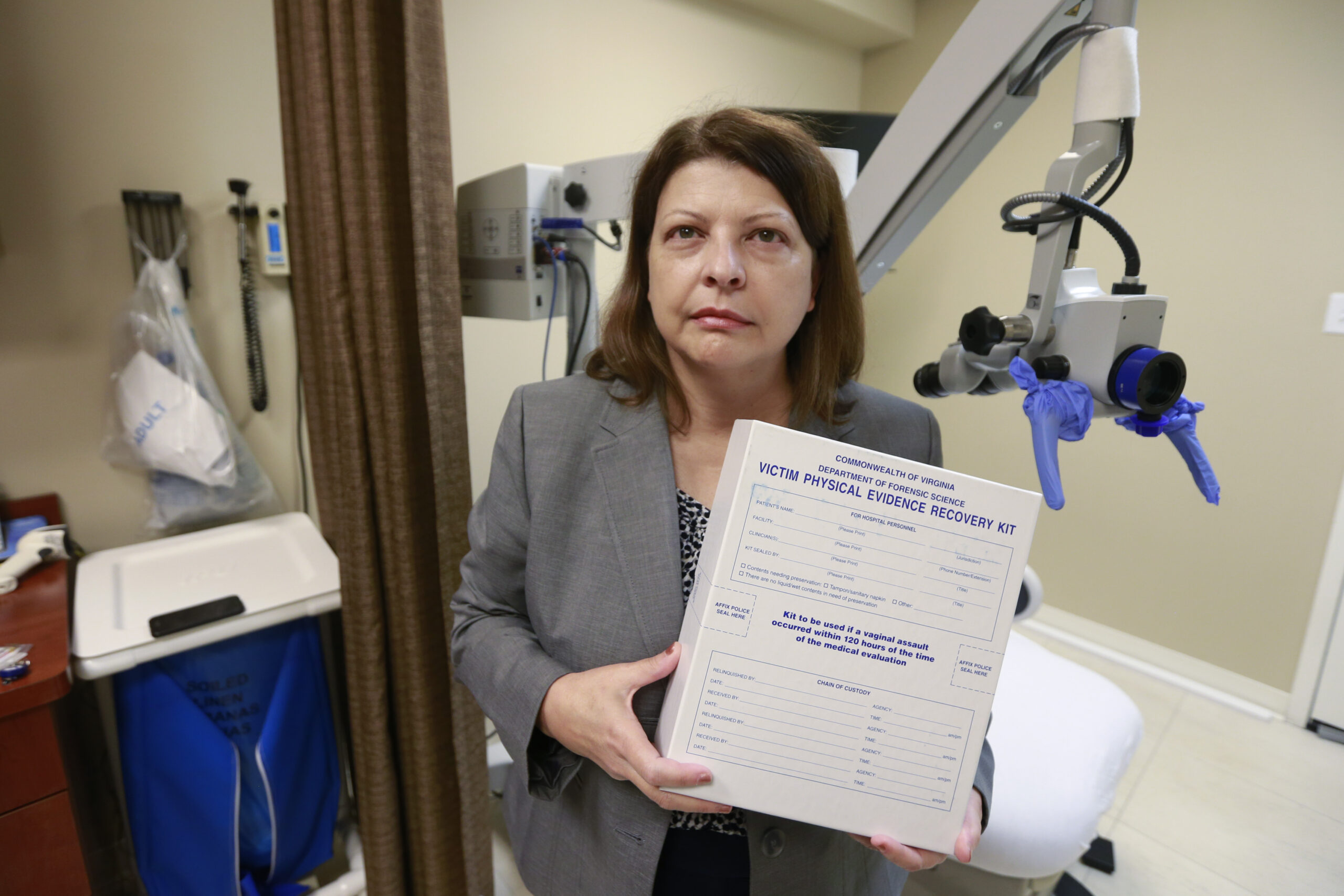 An educator holds a sexual assault evidence kit in an exam room