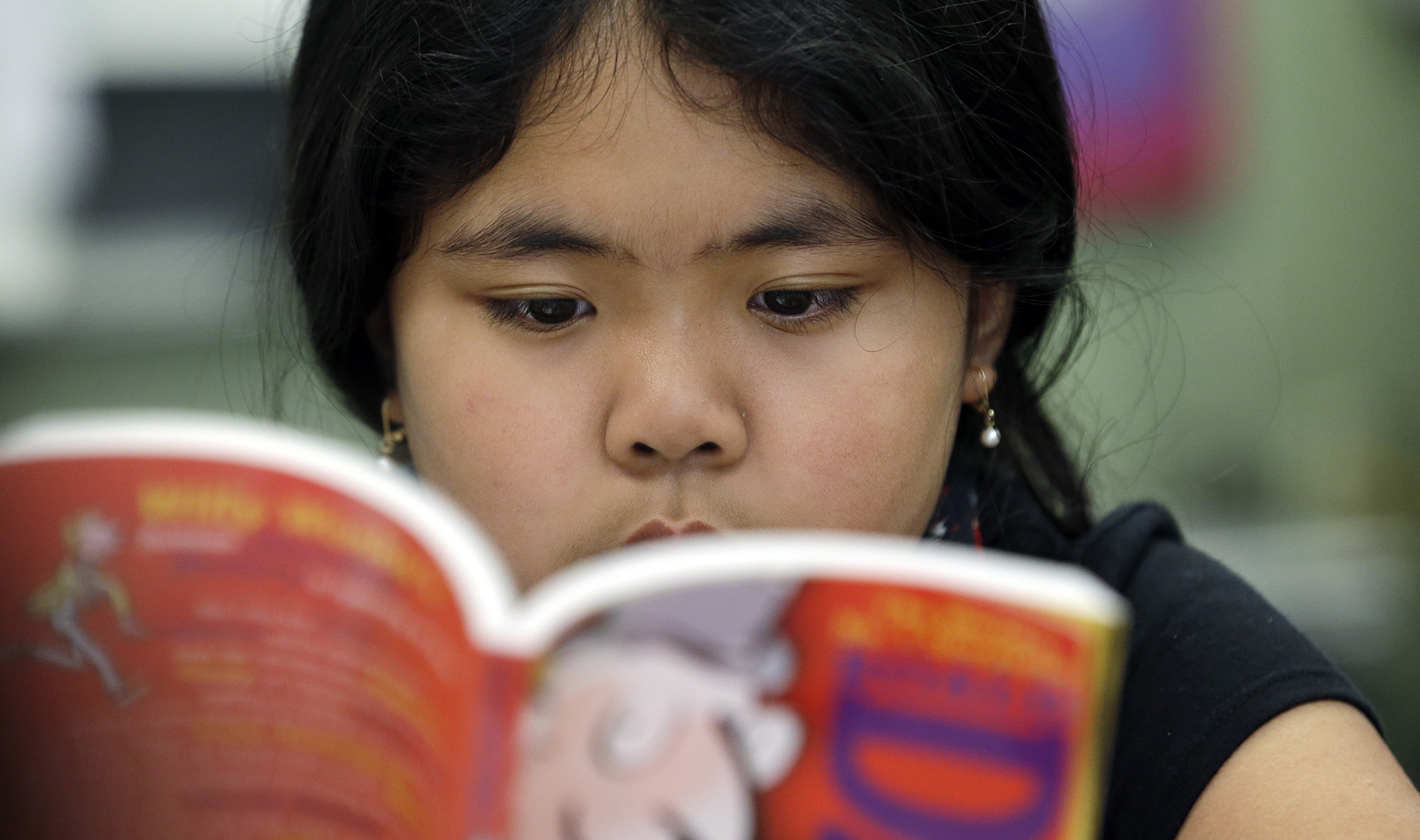 Fifth grader Kenna Sampayan reads a book during class.