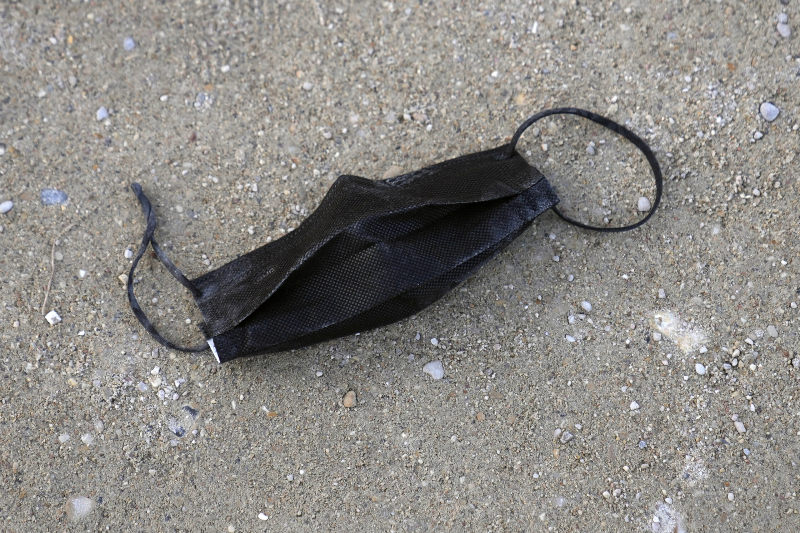 A used face mask lying on the ground