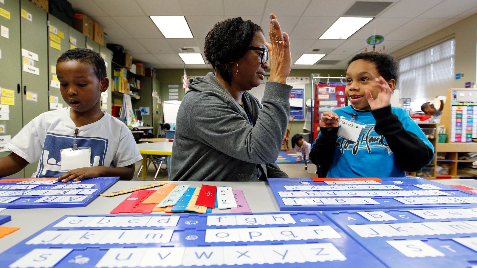 Kindergartener Malachi Stewart high-fives educational assistant Addison Hawk.