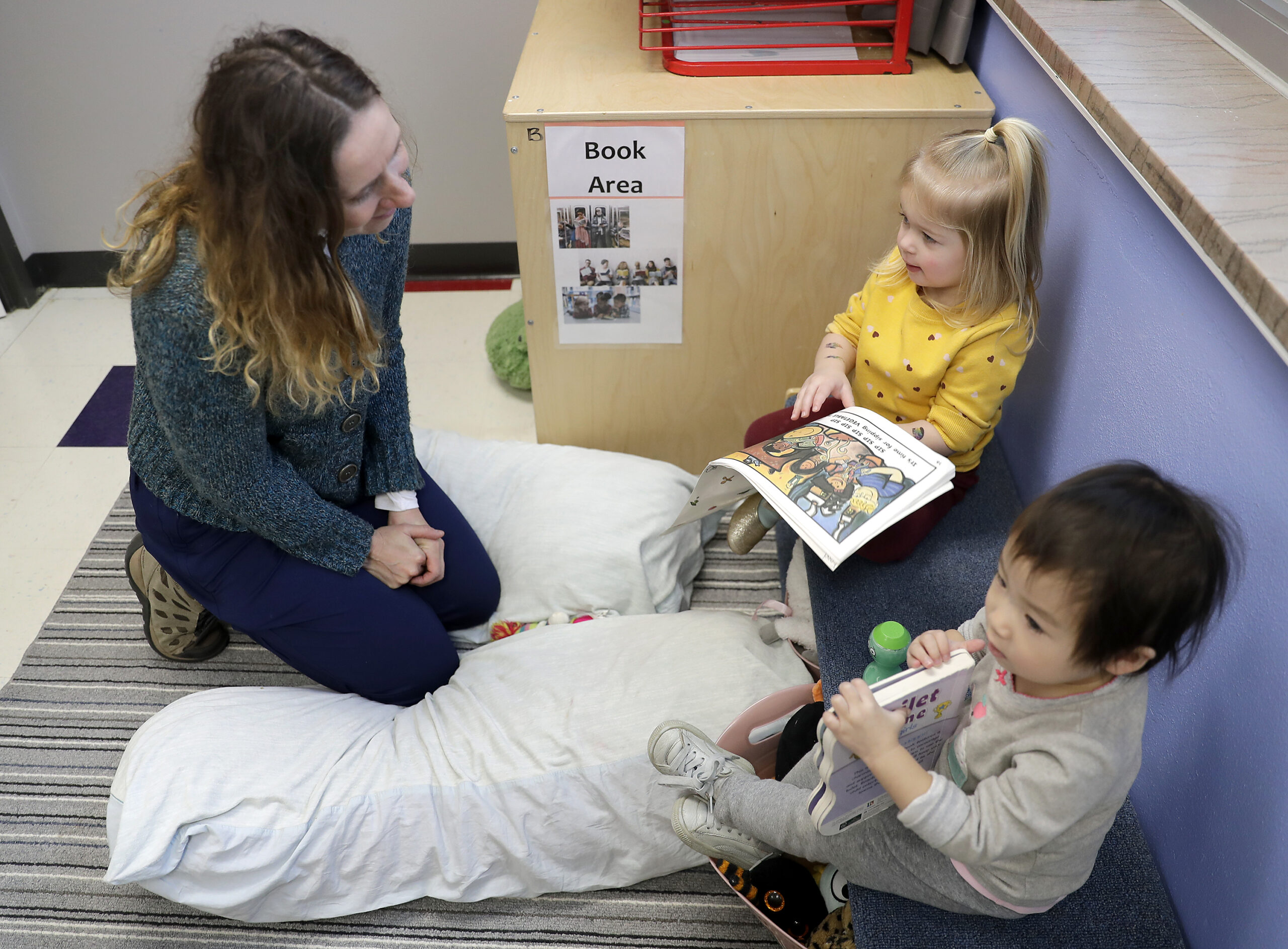 Wisconsin Department of Children and Families Secretary Emilie Amundson visits with Kynlee Giese, center, and Norah Zhang, right, during a visit at Bridges Child Enrichment Center