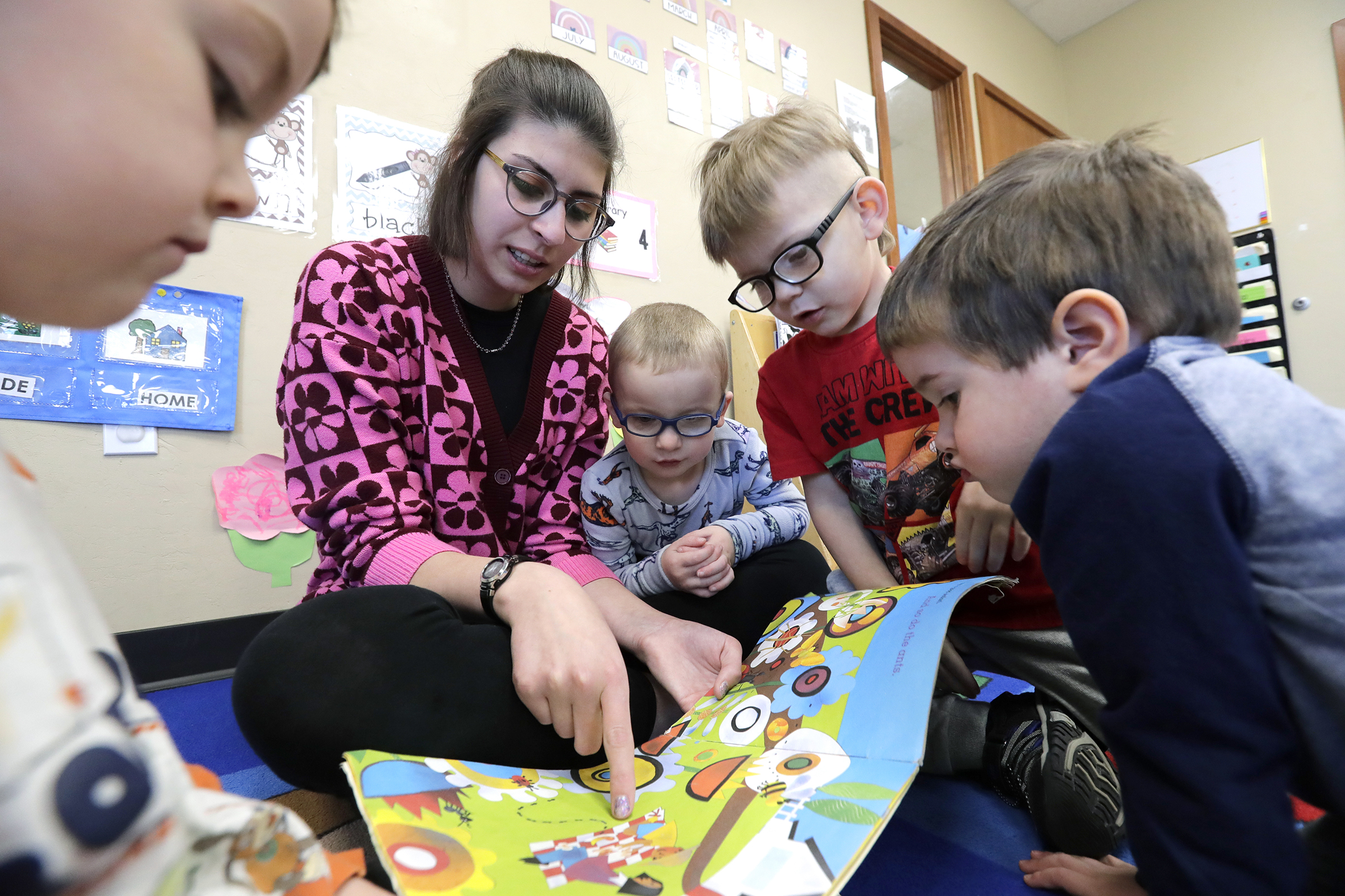 Vanessa Hanagan, an early childhood student teacher, reads to a group of children at Appletree Connections