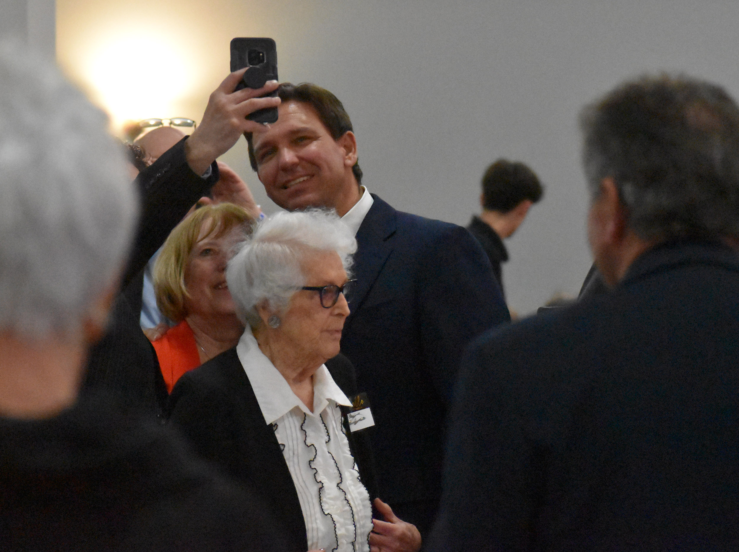 Florida Gov. Ron DeSantis takes a selfie with attendees of a Lincoln Day Dinner in Marathon County