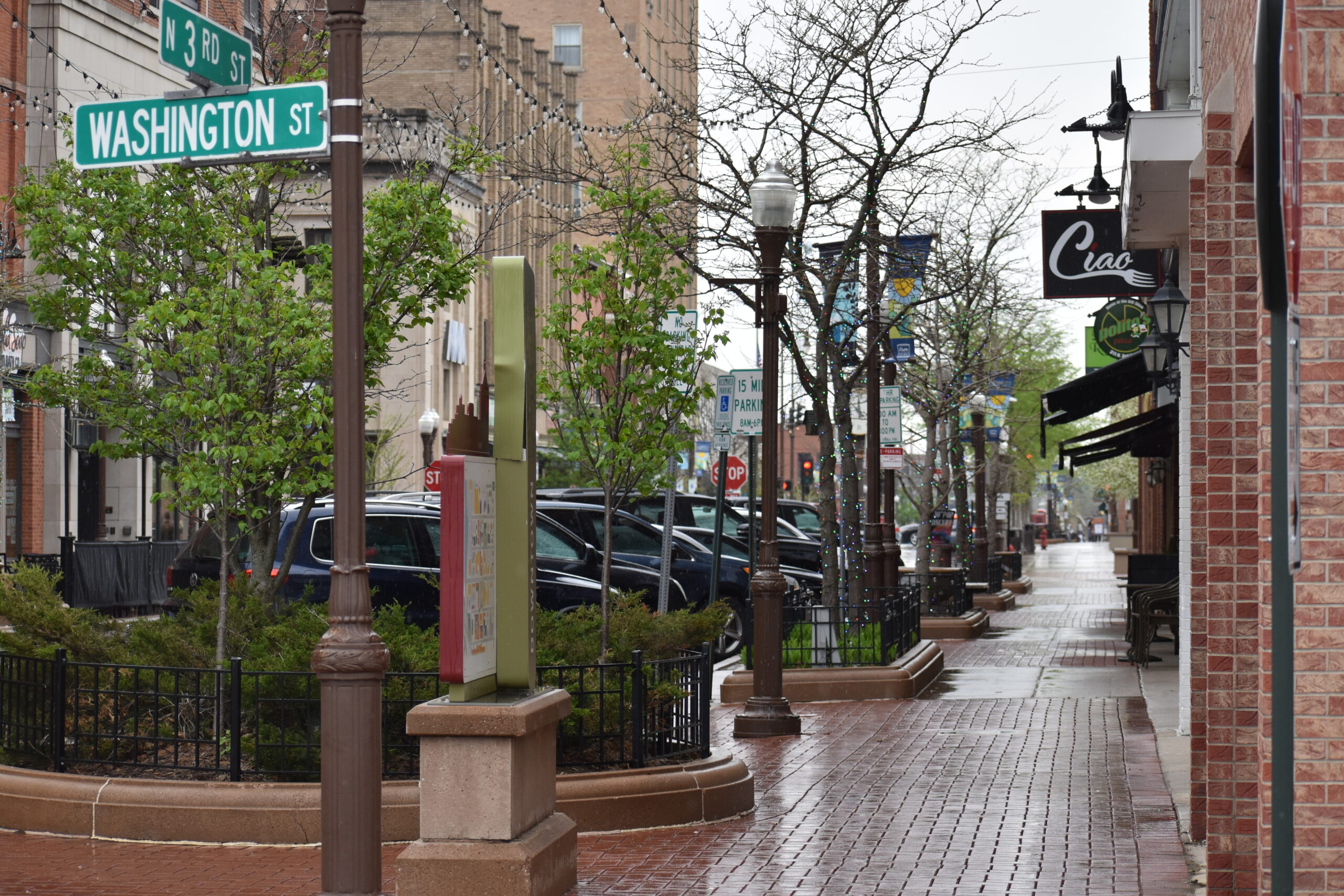 Cars are lined up along Third Street in downtown Wausau on a rainy spring day