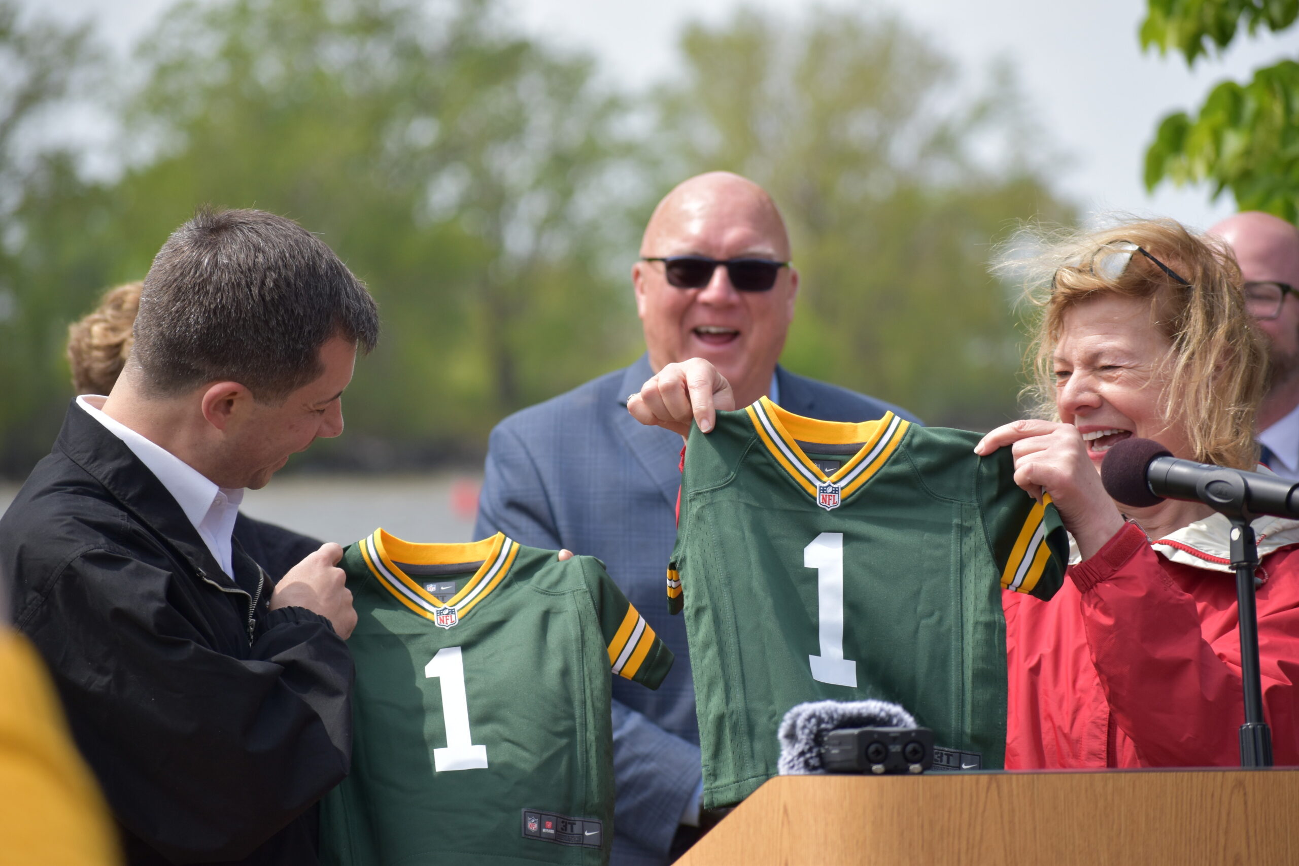 U.S. Sen. Tammy Baldwin, right, gifts U.S. Transportation Secretary Pete Buttigieg a pair of Green Bay Packers jerseys for his twins